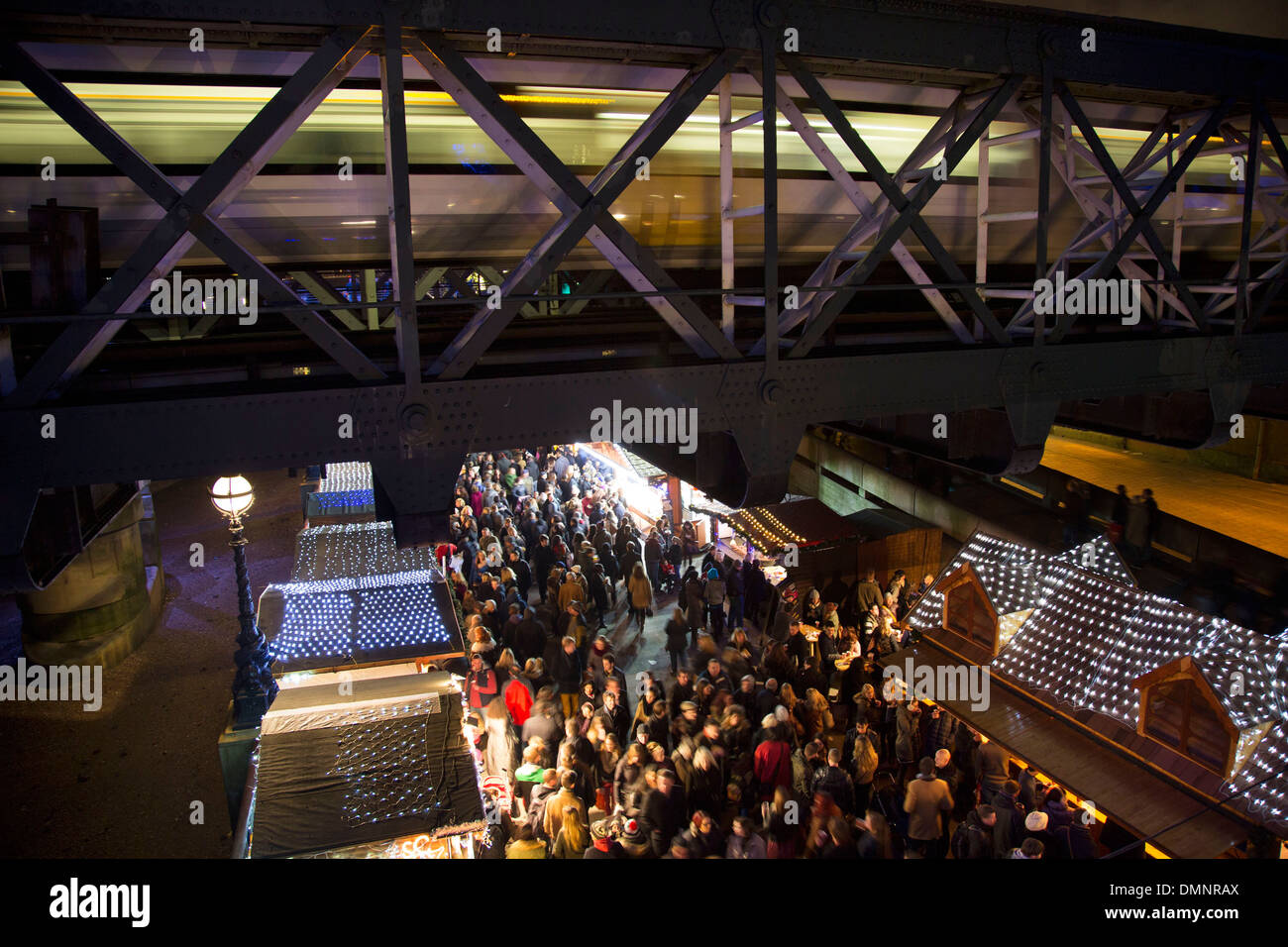 Riesige Menschenmengen sammeln auf dem Weihnachtsmarkt entlang der South Bank, wie ein Zug über Hungerford Bridge passiert. London, UK. Stockfoto