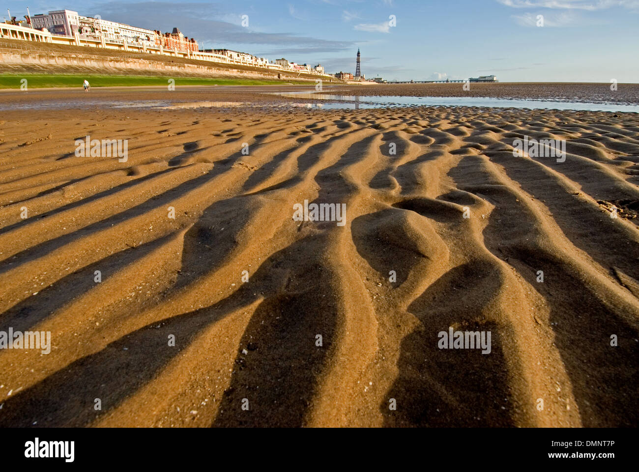 Ebbe in der irischen See macht weite Gebiete des plätschernden Sandstrände Blackpools Strandpromenade entlang. Stockfoto