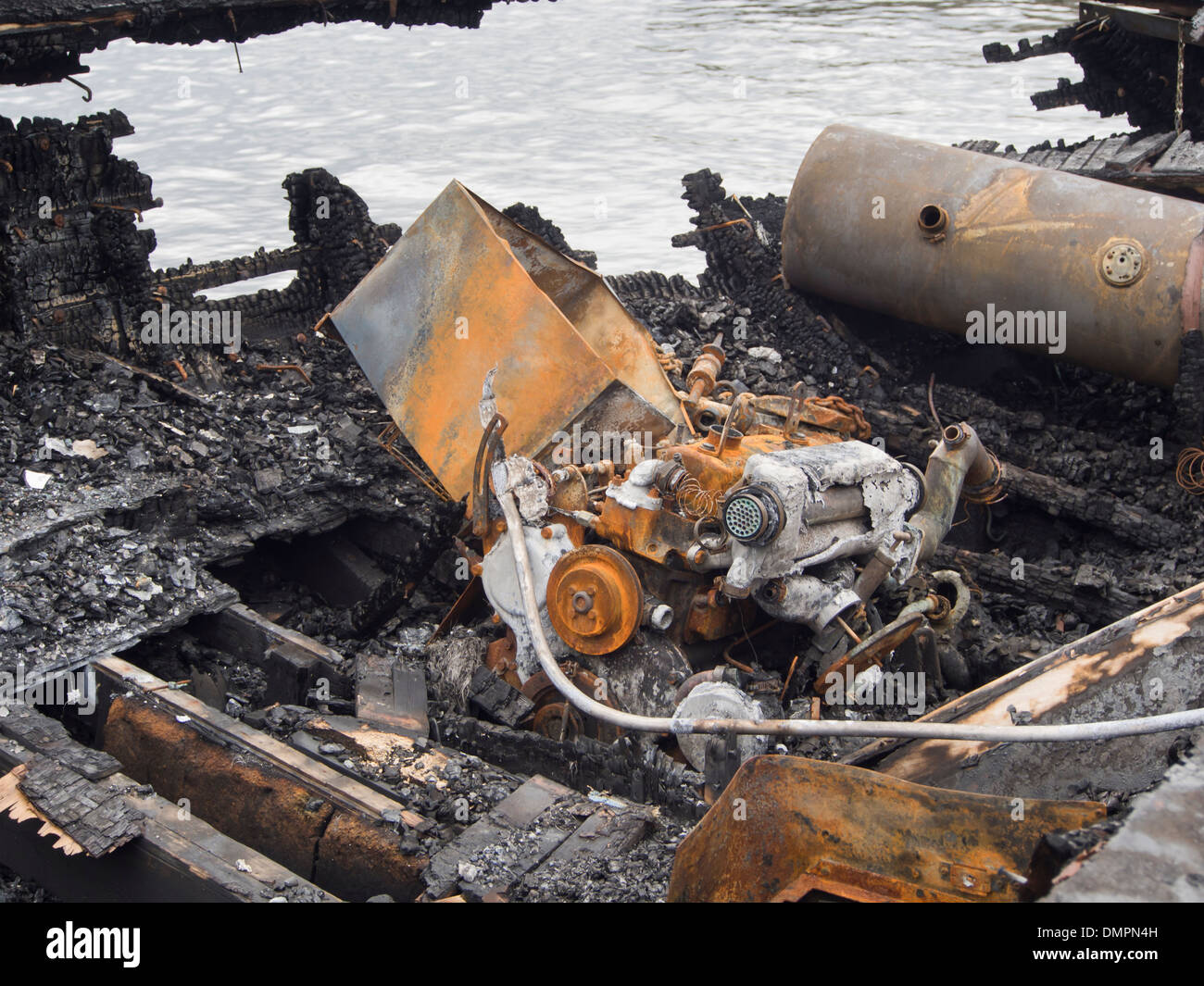 Reste von einem hölzernen Ausflugsschiff nach einem intensiven Feuer Holz rostigen Motorteile und einen rostigen Gasherd verkohlt Stockfoto