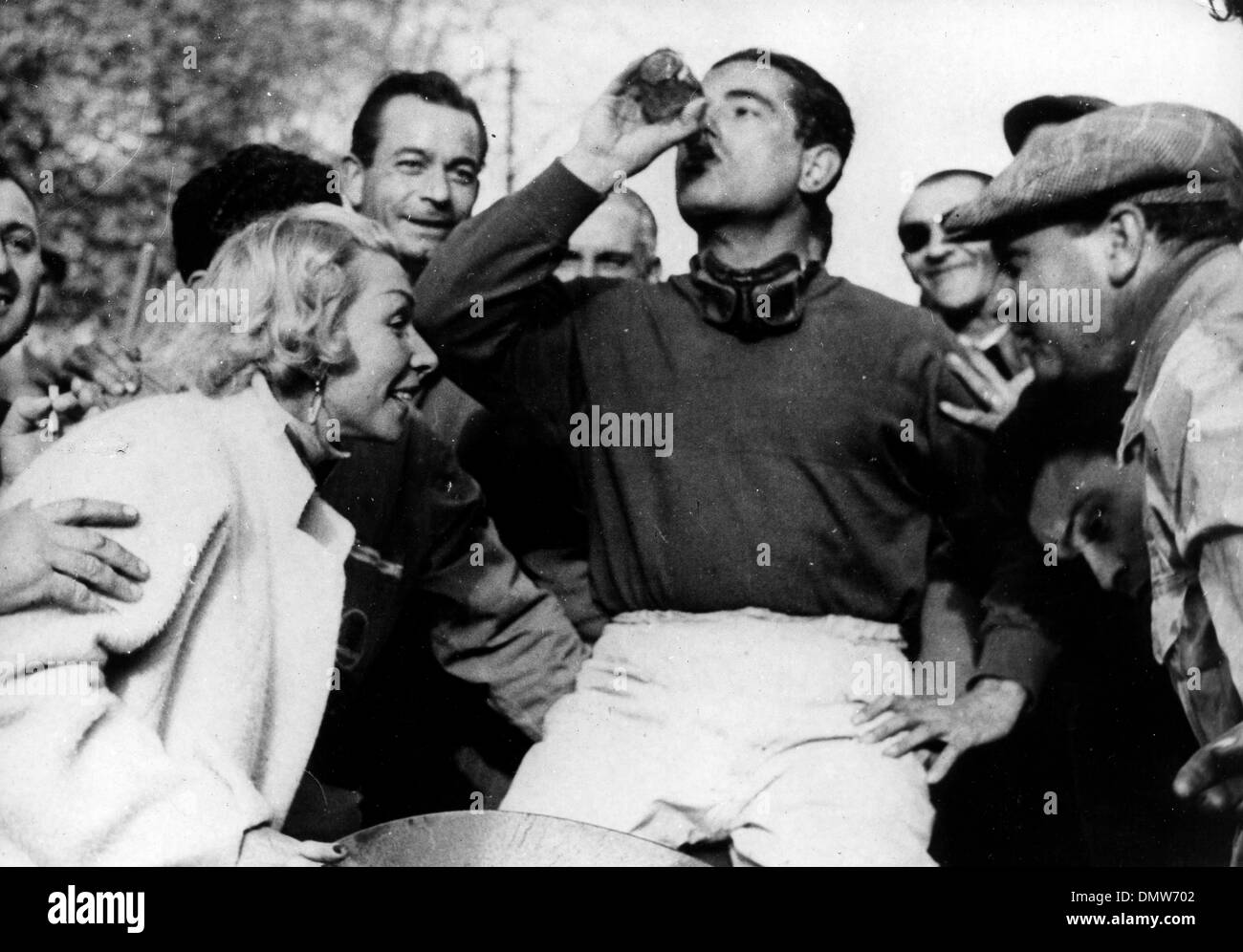 12. April 1955 - Pau, Frankreich - Rennfahrer nimmt JEAN BEHRA ein erfrischendes Getränk nach dem Gewinn des Grand-Prix-Rennen in Pau, ist mit ihm zu feiern seine Frau. (Kredit-Bild: © KEYSTONE Bilder USA/ZUMAPRESS.com) Stockfoto
