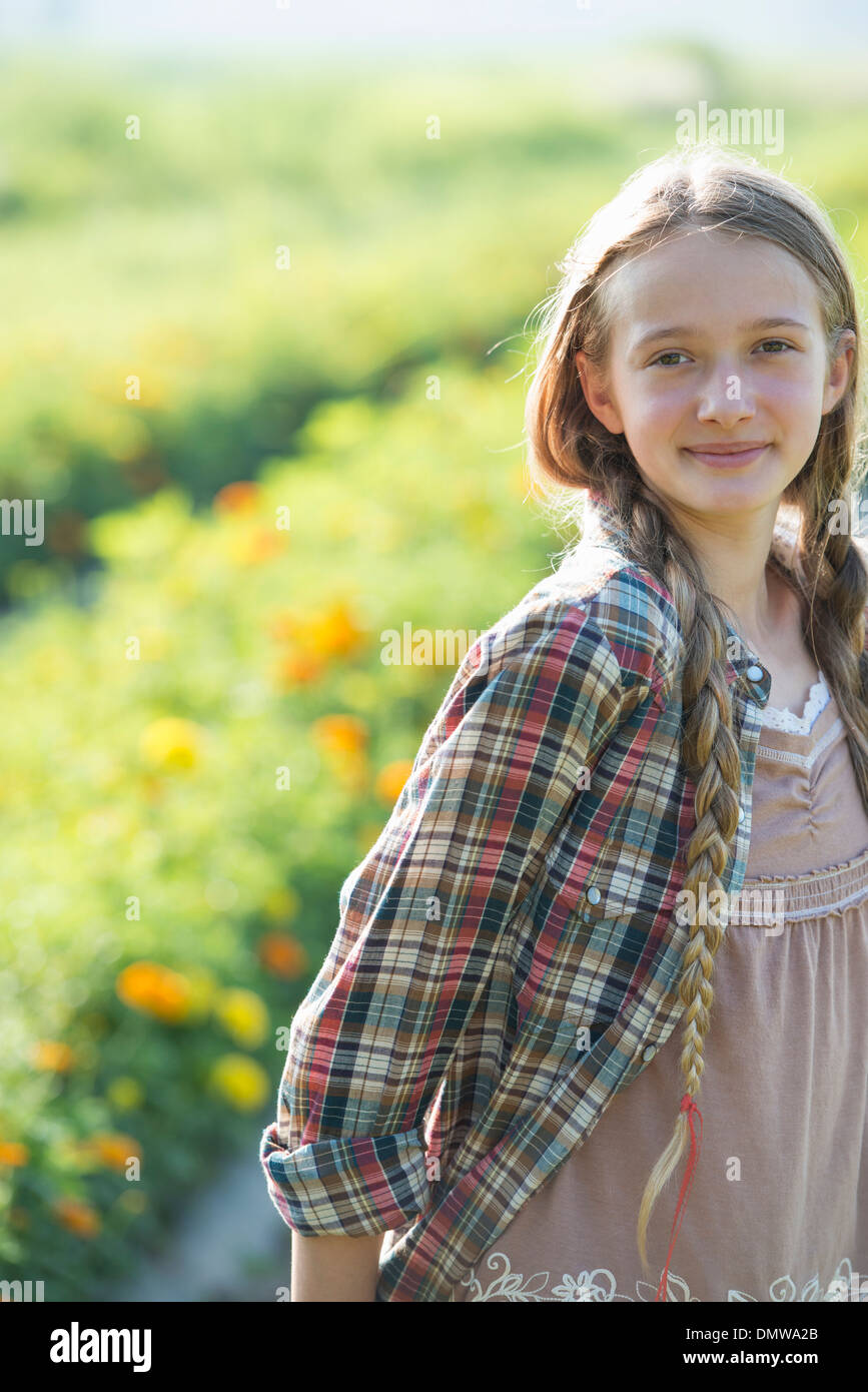 Im Sommer auf einem Bio-Bauernhof. Ein junges Mädchen in einem Feld von Blumen. Stockfoto