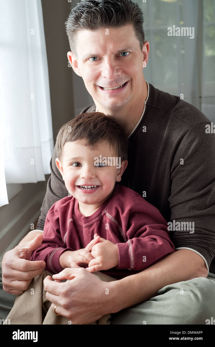 Ein Vater seinen Sohn, lächelnd, ein Familienporträt umarmt. Stockfoto