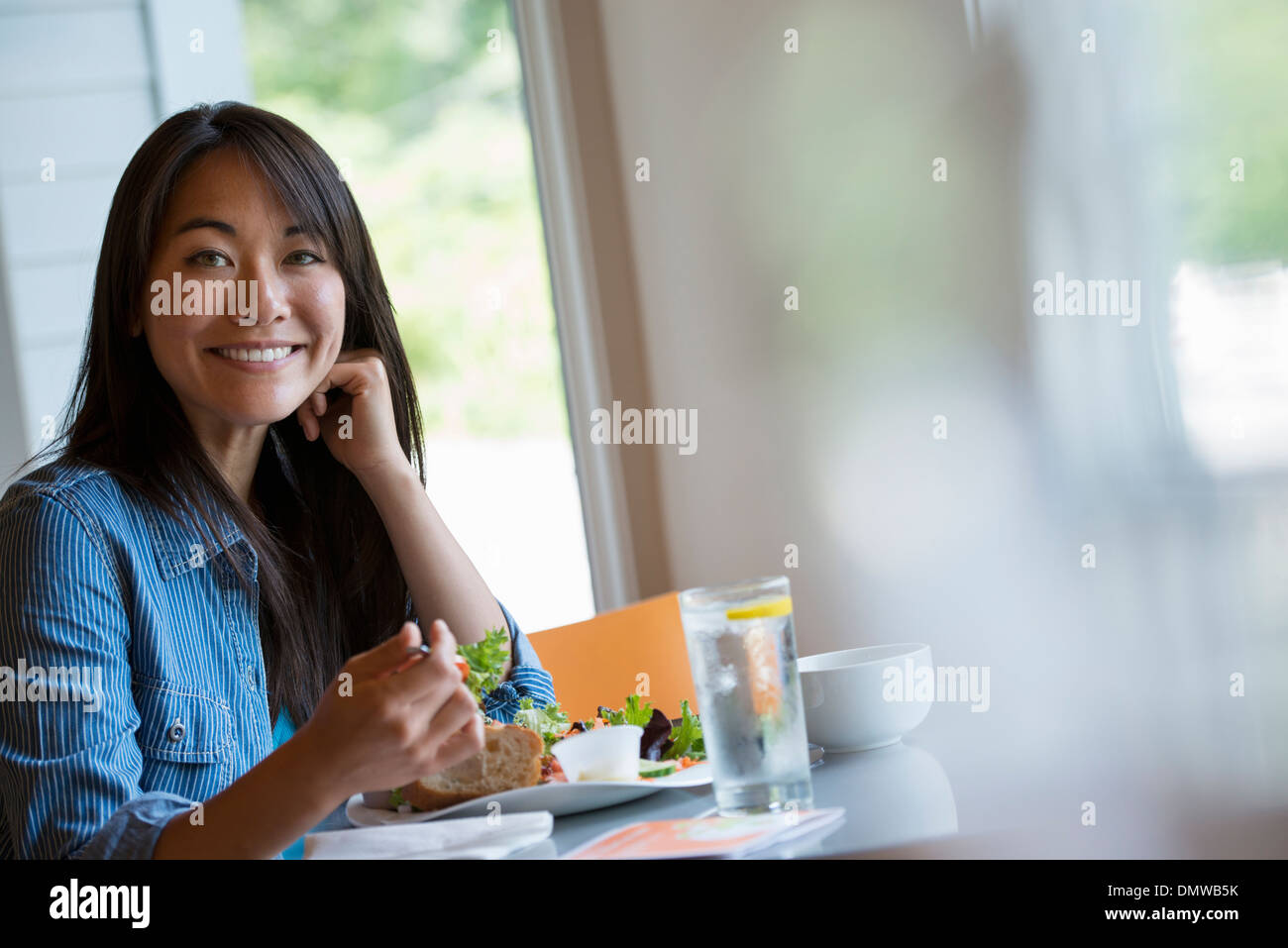 Eine Frau sitzt in einem Café Essen. Stockfoto