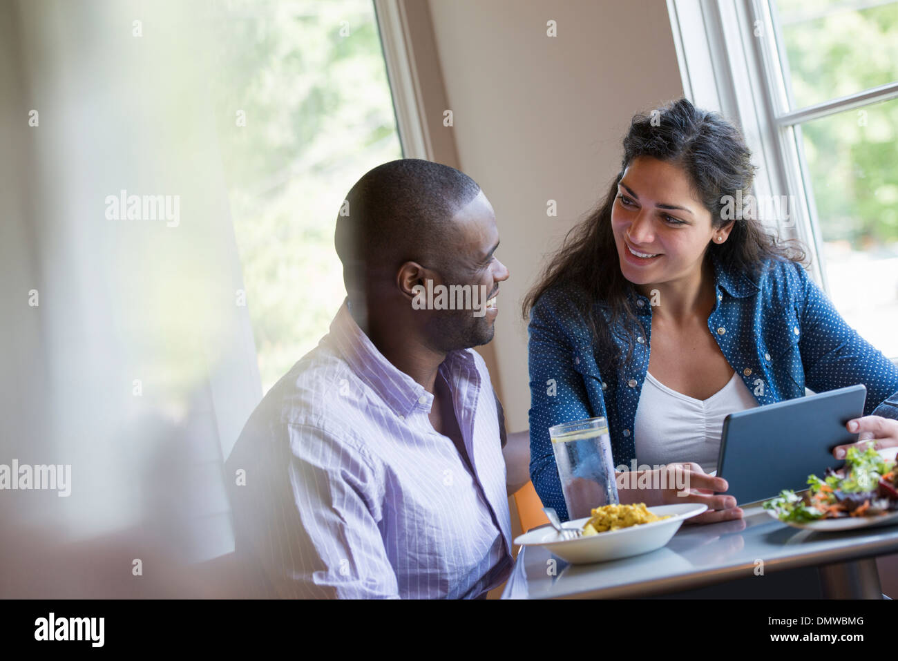 Ein paar sitzt ein digital-Tablette zu betrachten. Stockfoto