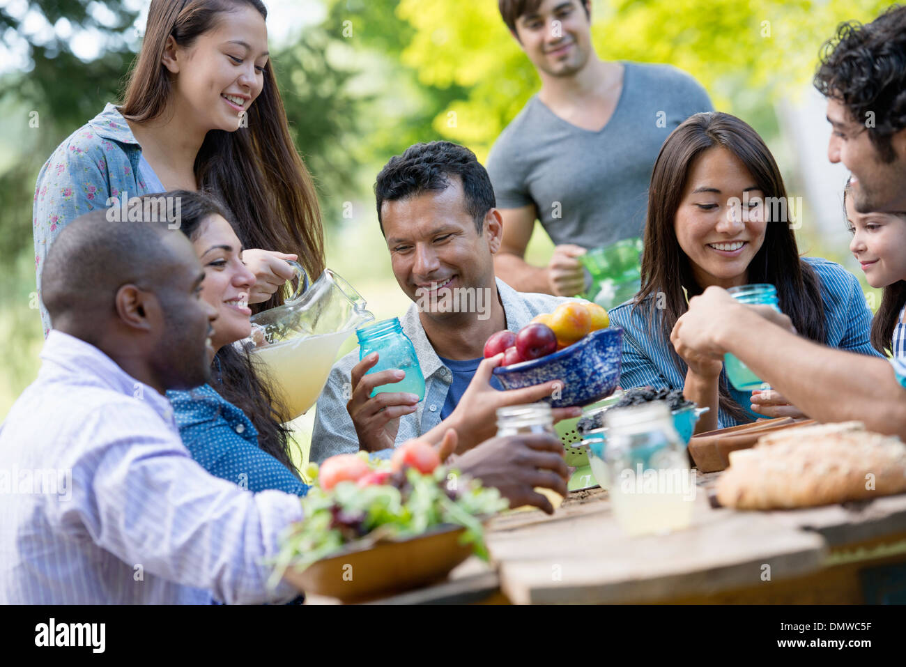 Erwachsene und Kinder an einem Tisch im Garten. Stockfoto