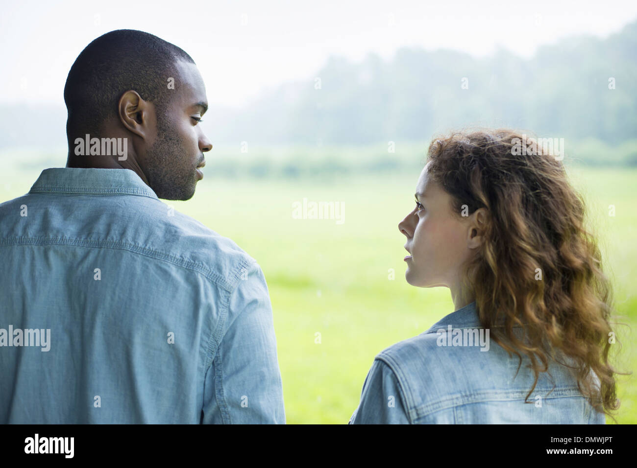 Ein junger Mann und eine Frau ein paar nebeneinander. Betrachtet man jede oder. Stockfoto
