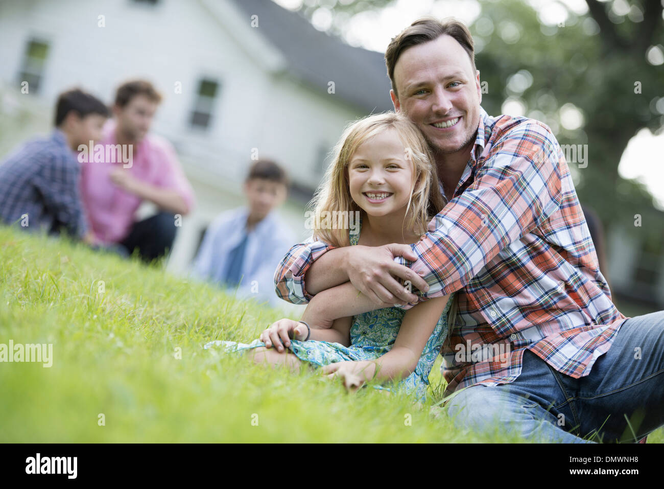 Vater und Tochter auf einem Sommerfest auf dem Rasen sitzen. Stockfoto