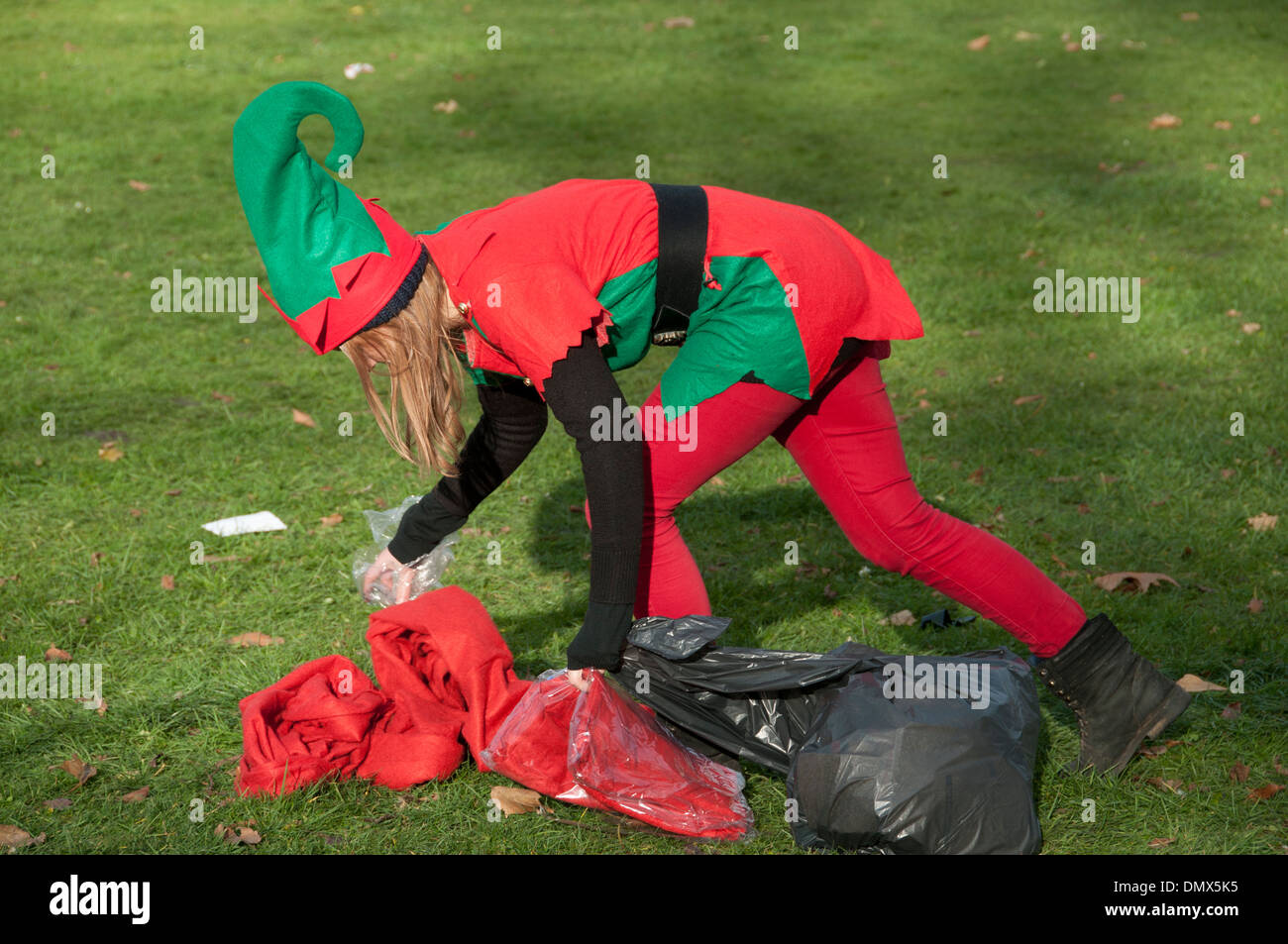 Santa Run, organisiert mit Menschen in Santa Anzügen zugunsten verschiedene Wohltätigkeitsorganisationen, von "Doitforcharity". Ein "Elf" sammelt Müll Stockfoto