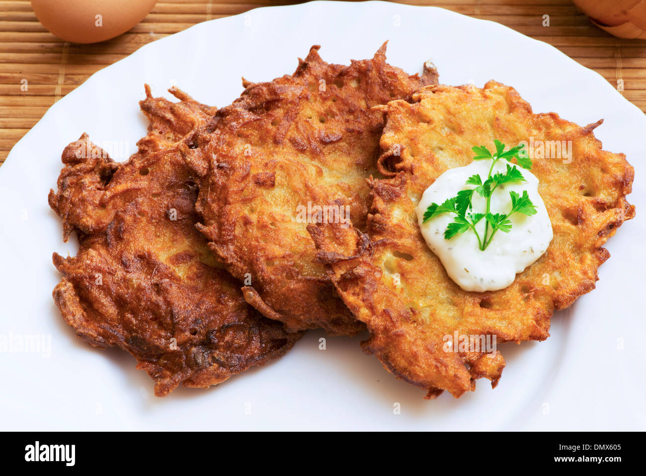 Kartoffelpuffer mit saurer Sahne und Petersilie Stockfoto