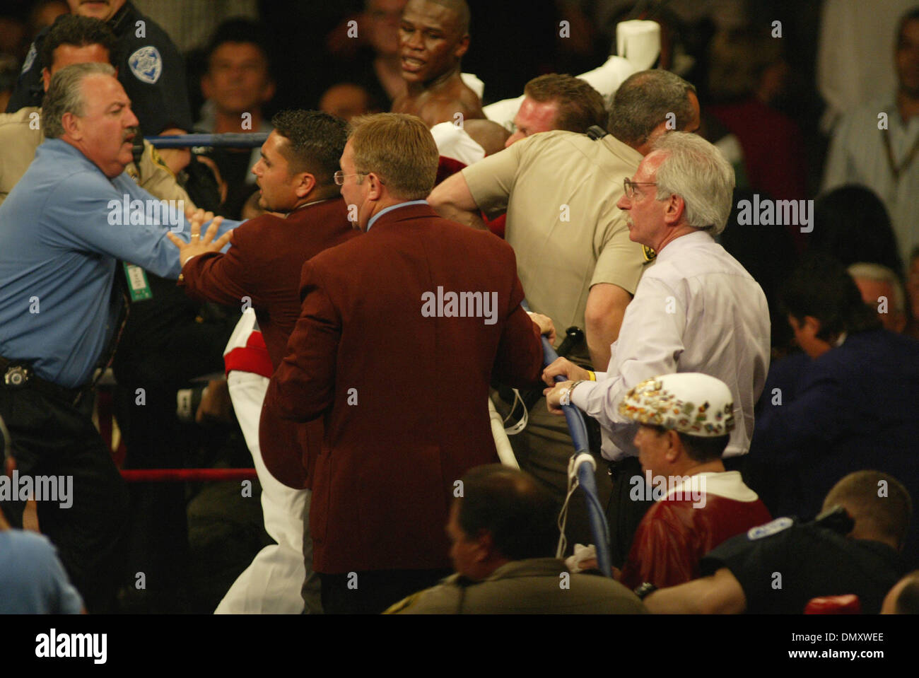8. April 2006; Las Vegas, NV, USA; FLOYD MAYWEATHER JR. Vs ZAB JUDAH IBF im Weltergewicht kämpfen. Wenn JUDA gestanzt MAYWEATHER unter die Gürtellinie Trainer ROGER MAYWEATHER (weiße & roten Jogginganzug) & Onkel sprang in den Ring & ging nach ZAB JUDHA (R) rote & schwarze Stämme. Nevada athletic Chief Inspector TONY LATO Hintergrund Blau Hemd & Inspektoren in Burgund Jacken zusammen mit der Metro p Stockfoto