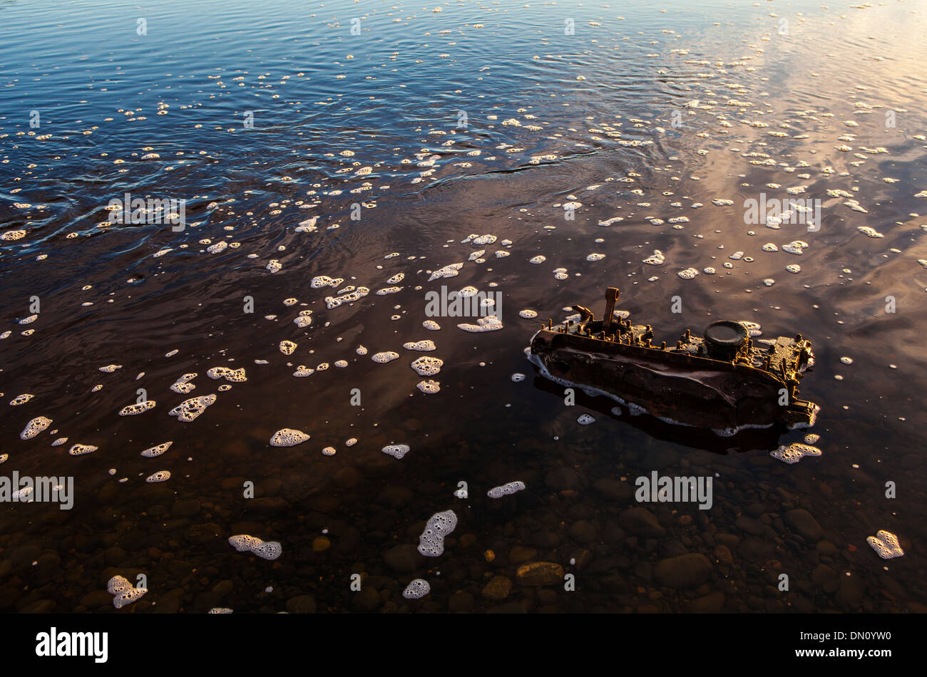 Ein Motorblock im Bach Wasser mit Schaum Bläschen an der Oberfläche. Stockfoto