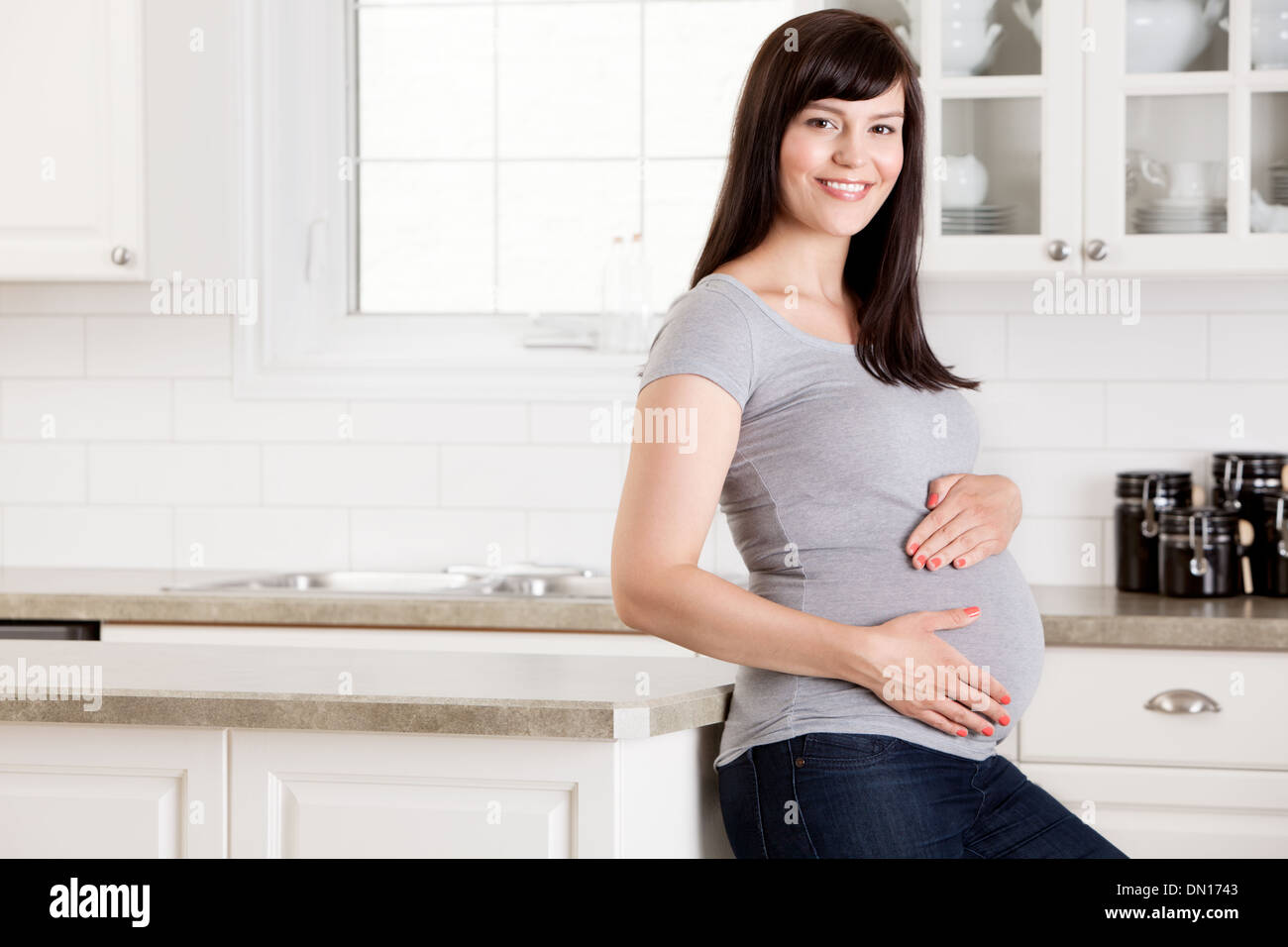 Schwangere Frau mit Händen am Bauch Stockfoto