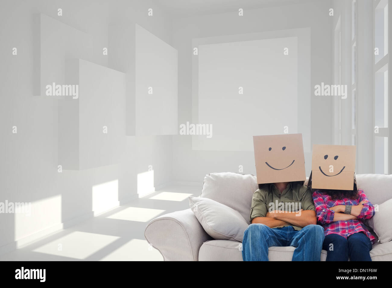 Zusammengesetztes Bild dumme Mitarbeiter mit Waffen tragen Faltschachteln auf ihren Köpfen Stockfoto