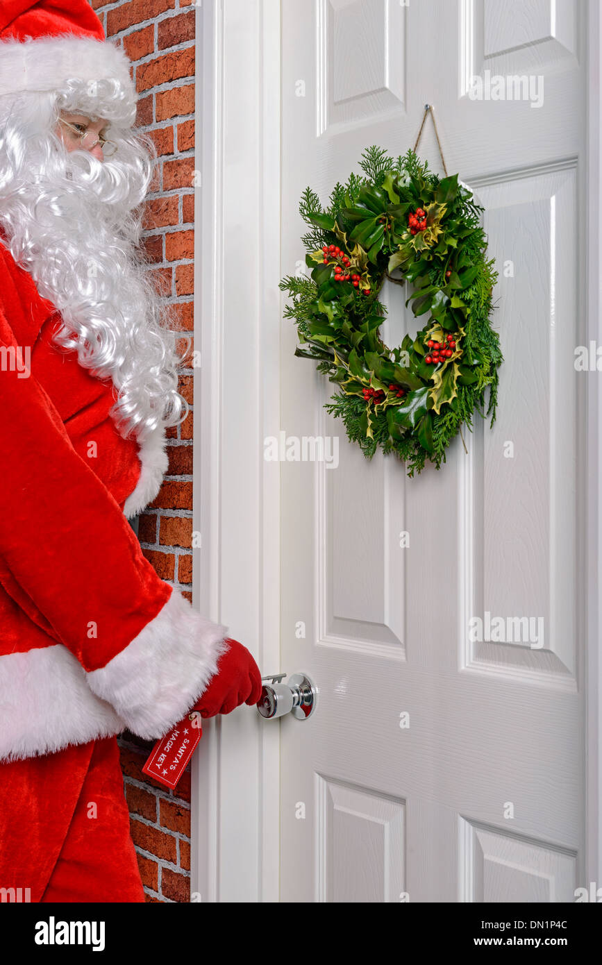 Santa mit seinem magischen Schlüssel eine Tür zu öffnen, damit er die Geschenke zu verteilen. Stockfoto