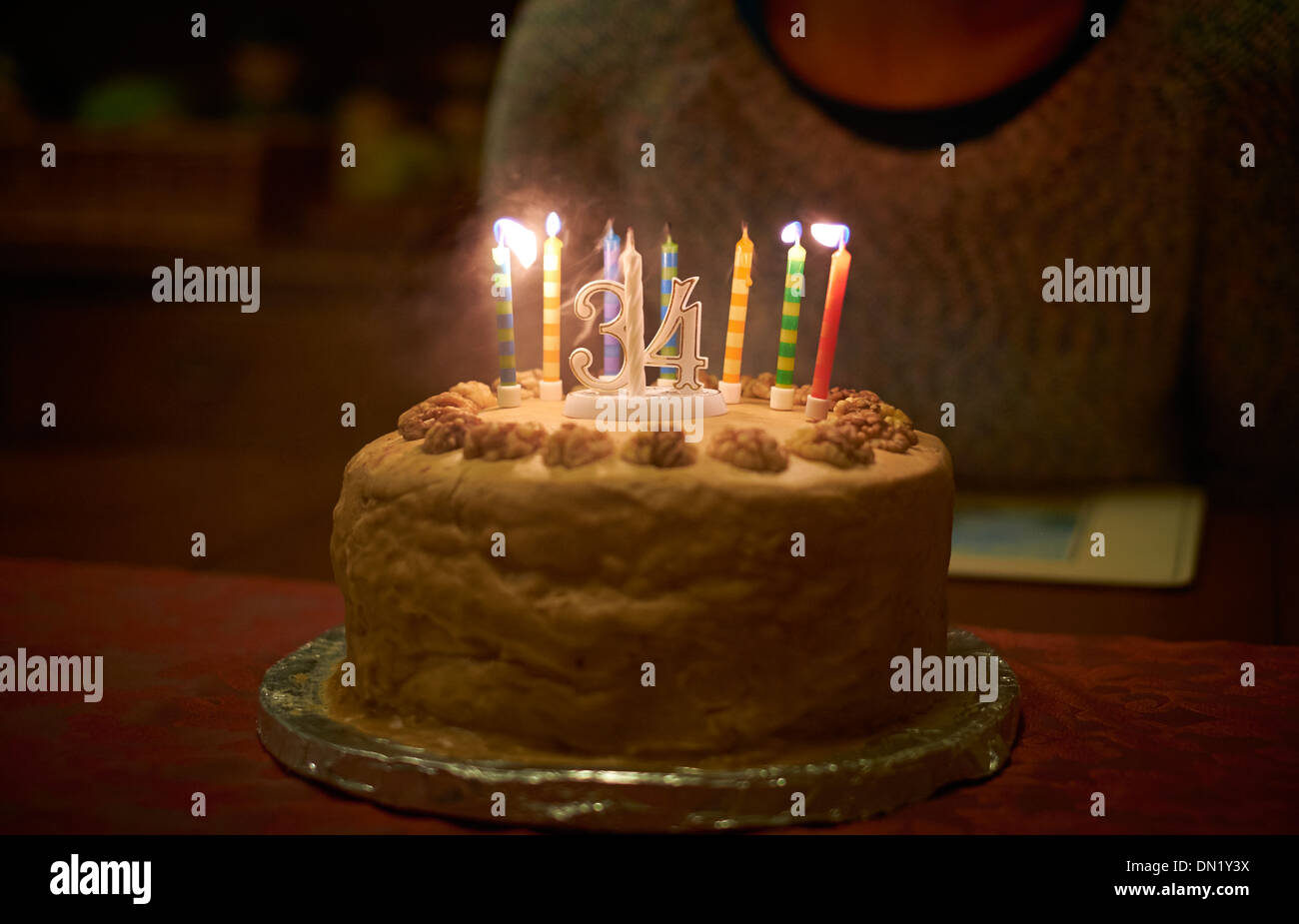Ausblasen von Kerzen auf einer 34. Geburtstagstorte, feiert der dreißiger Jahre. Stockfoto