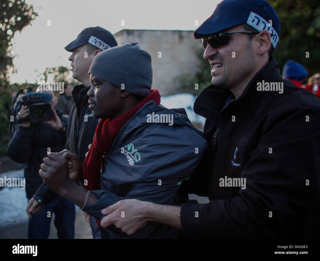 Jerusalem, Knesset (Parlament) in Jerusalem. 18. Dezember 2013. Israelische Einwanderung Polizisten zwingen einen afrikanischen Asylbewerber auf einen Bus in Richtung zu einem Gefängnis während einer Protestaktion vor der Knesset (Parlament) in Jerusalem, am 17. Dezember 2013. Einige 200 afrikanische Asylbewerber protestieren vor dem israelischen Ministerpräsidenten Büro gegen ein Gesetz, so dass um sie auf unbestimmte Zeit in Haft zu halten wurden verhaftet und wieder in Haftanstalten, berichteten lokale Medien. Bildnachweis: Muammar Awad/Xinhua/Alamy Live-Nachrichten Stockfoto