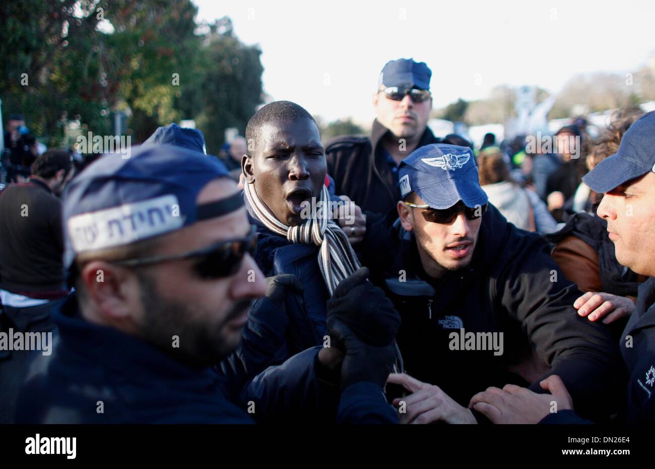 Jerusalem, Knesset (Parlament) in Jerusalem. 18. Dezember 2013. Israelische Einwanderung Polizisten zwingen einen afrikanischen Asylbewerber auf einen Bus in Richtung zu einem Gefängnis während einer Protestaktion vor der Knesset (Parlament) in Jerusalem, am 17. Dezember 2013. Einige 200 afrikanische Asylbewerber protestieren vor dem israelischen Ministerpräsidenten Büro gegen ein Gesetz, so dass um sie auf unbestimmte Zeit in Haft zu halten wurden verhaftet und wieder in Haftanstalten, berichteten lokale Medien. Bildnachweis: Muammar Awad/Xinhua/Alamy Live-Nachrichten Stockfoto