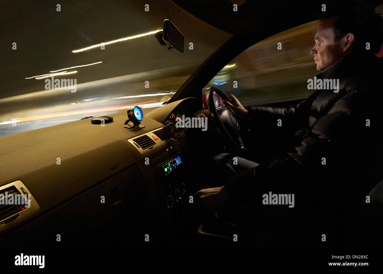 Eine Innenansicht eines Mannes, ein Auto zu fahren, schnell in der Nacht. Stockfoto