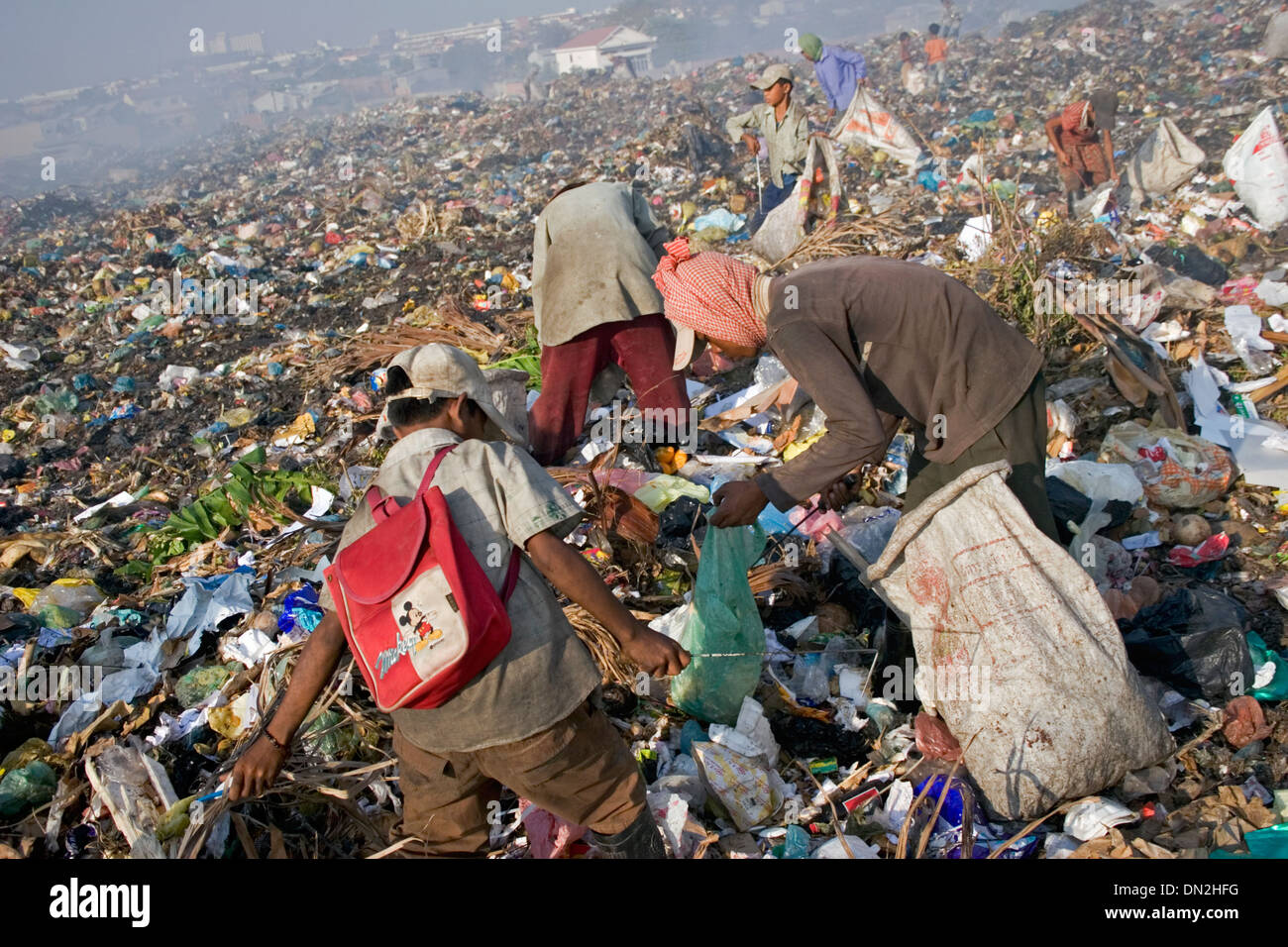 Ein junges Kind Arbeiter junge trägt einen Rucksack während der Arbeit an der Stung Meanchey Deponie in Phnom Penh, Kambodscha. Stockfoto