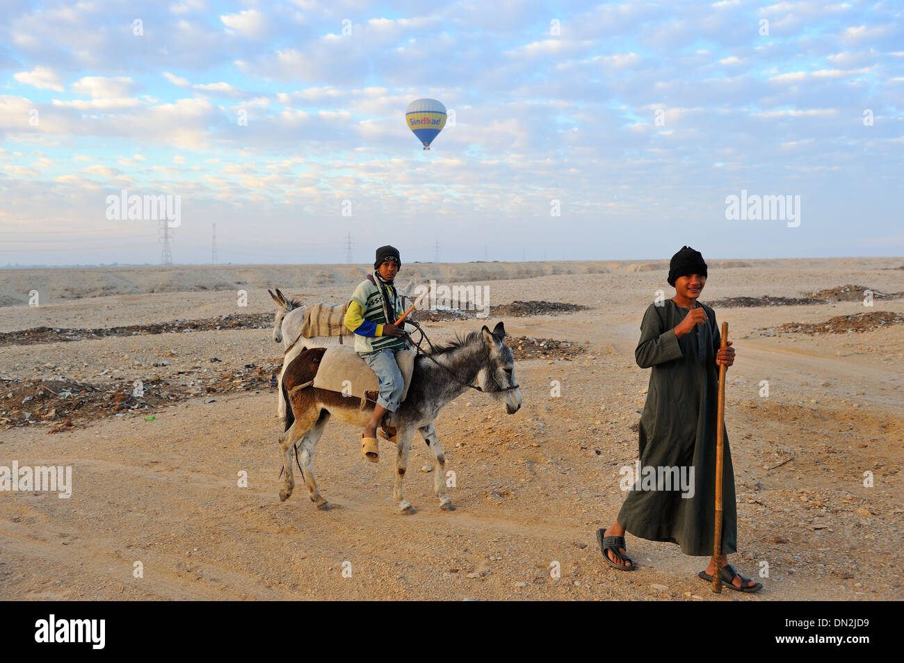 Einheimische Kinder eilen, um Luftballons zu treffen, wie sie landen - Westbank von Luxor, Oberägypten Stockfoto