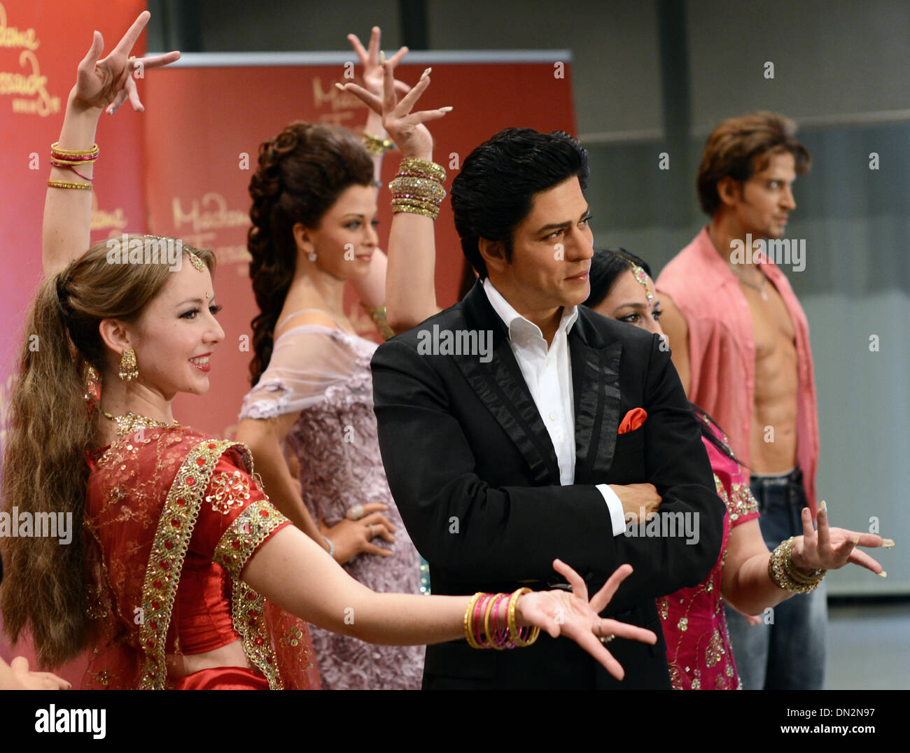 Berlin, Deutschland. 18. Dezember 2013. Tänzer der Bollywood-Tanzgruppe "Klingelte De Zaraa Vi" präsentieren die Wachsfiguren von Bollywood-Stars Aishwarya Rai (2-L), Shah Rukh Khan (3-L) und Hrithik Roshan (R) bei der indischen Botschaft in Berlin, Deutschland, 18. Dezember 2013. Für die nächsten drei Monate werden Wachsfiguren von fünf Bollywood-Stars auf das Wachsfigurenkabinett Madame Tussauds Berlin ausgestellt. Foto: JENS KALAENE/Dpa/Alamy Live News Stockfoto