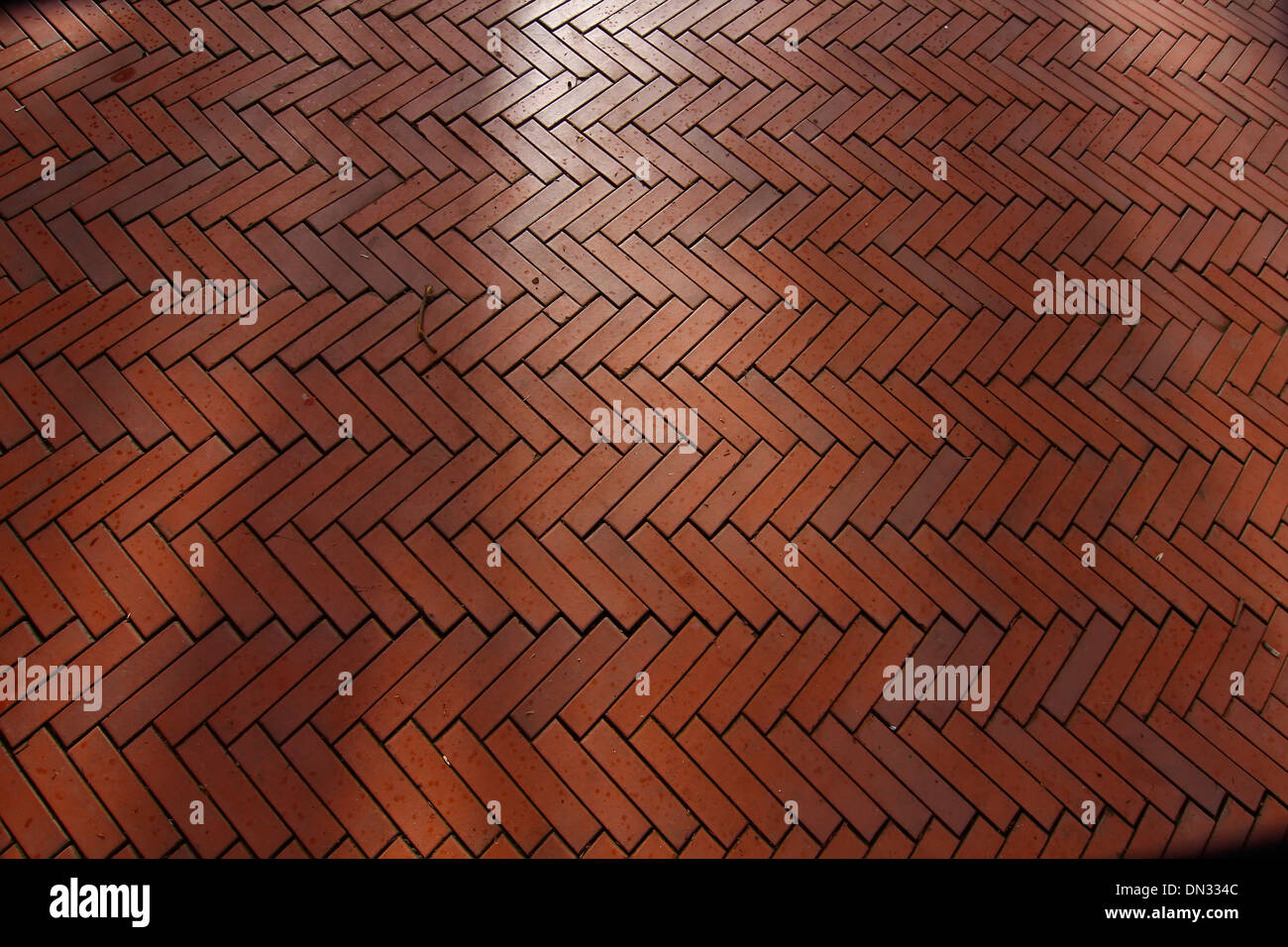 Hintergrund mit roten Ziegeln in einem Fischgrätmuster gemacht Stockfoto
