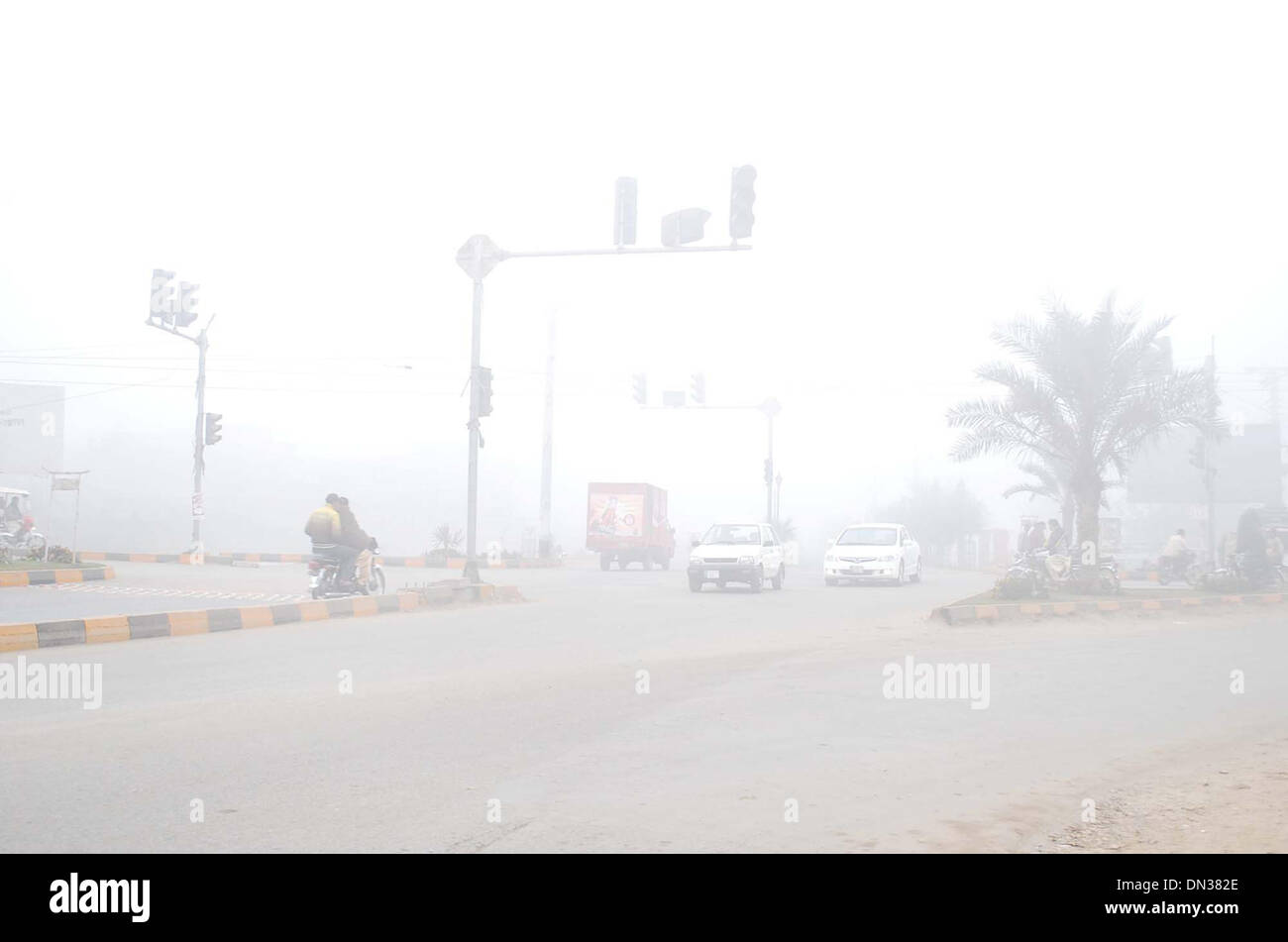 Pendler werden in extreme Schwierigkeiten während der Fahrt durch nebliges Wetter während der Wintersaison in Sialkot auf Mittwoch, 18. Dezember 2013. Mindestens 19 Menschen starben und Dutzende Verletzte bei Verkehrsunfällen aufgrund schlechter Sicht als Dichter Nebel bedeckt, verschiedene Städte und weite Gebiete des Punjab nachteilig beeinflussen den Alltag und die Straßen-, Schienen-und Luftverkehr zu stören. Stockfoto