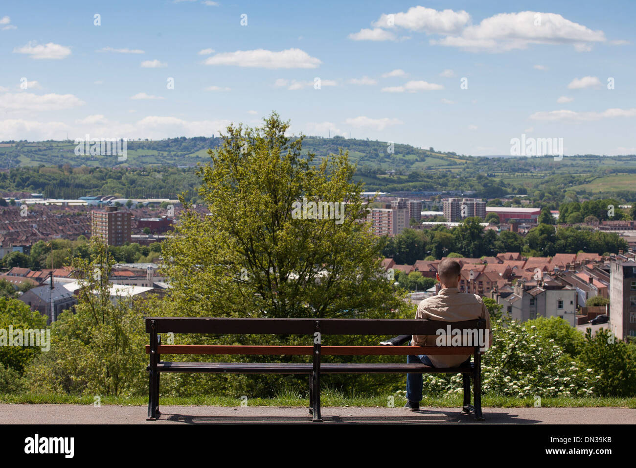 Ein Mann sitzt auf einer Bank in einem Park mit Blick auf Bristol, wie viel des Vereinigten Königreichs endlich Sommerwetter erlebt. 1. Juni 2013. Stockfoto