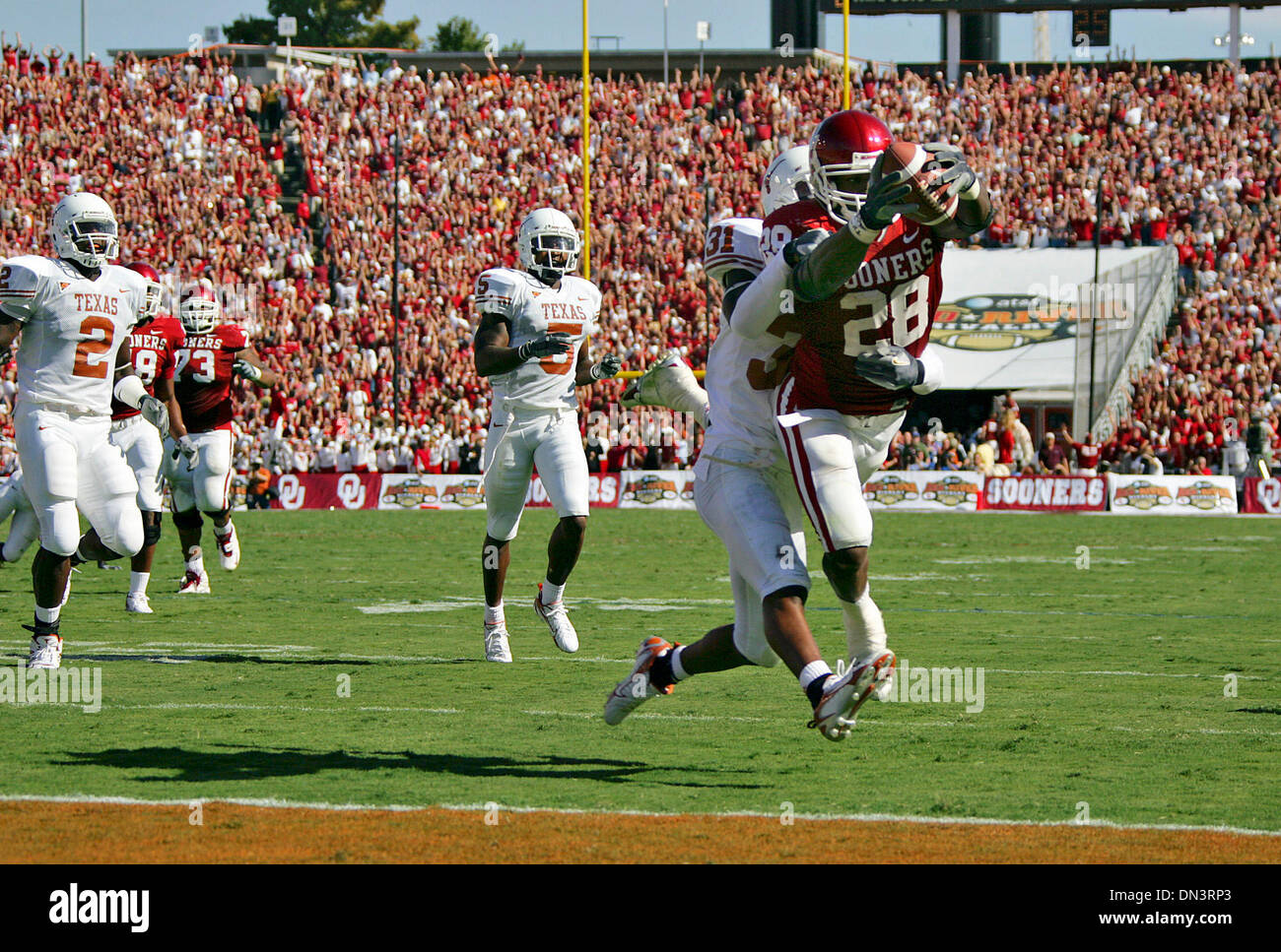 7. Oktober 2006; Dallas, TX, USA; NCAA Football: Adrian Peterson taucht in der Endzone wie Aaron Ross auf einen Touchdown laufen in der ersten Hälfte der Red River Rivalität zwischen den Texas Longhorns und Oklahoma Sooners Samstag, 7. Oktober 2006 in das Cotton Bowl verteidigt.  Obligatorische Credit: Foto von Bahram Mark Sobhani/San Antonio Express-News/ZUMA Press. (©) Copyright 2006 von San Antonio E Stockfoto