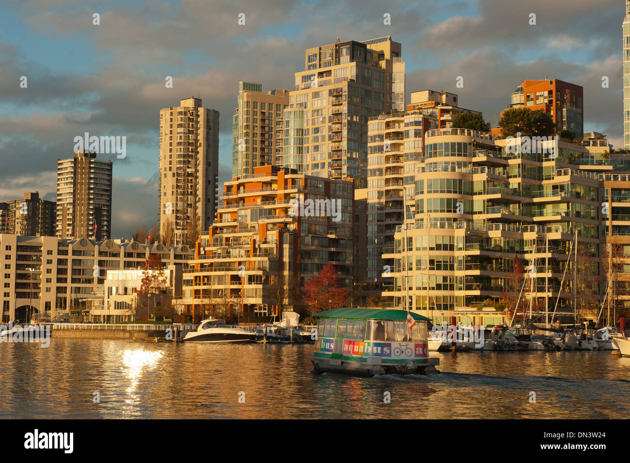 Reflexion von Yaletown Mehrfamilienhäusern bei Sonnenuntergang auf False Creek von Granvile Island, Vancouver BC Kanada Stockfoto