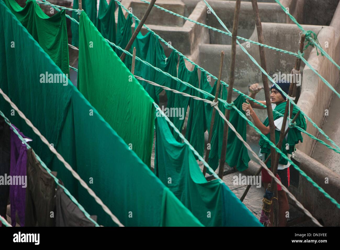 Mumbai, Indien. 18. Dezember 2013. Ein Arbeiter trocknet die Kleidung am Dhobi Ghat in Mumbai, Indien, 18. Dezember 2013. Dhobi Ghat, mit mehr als 150 Jahren Geschichte, findet in der Innenstadt von Mumbai. Es wird als die weltweit größte Open-Air-Waschsalon aufgezeichnet. Die Unterlegscheiben, lokal bekannt als Dhobis, arbeiten im Freien für Besitzer der Teiche Wäsche zum Waschen der Kleidung von Mumbais Hotels und Krankenhäuser. Sie Leben mit ihrer Familie in den Dhobi Ghat, Hunderte von indischen Rupien pro Tag zu verdienen. © Zheng Huansong/Xinhua/Alamy Live-Nachrichten Stockfoto