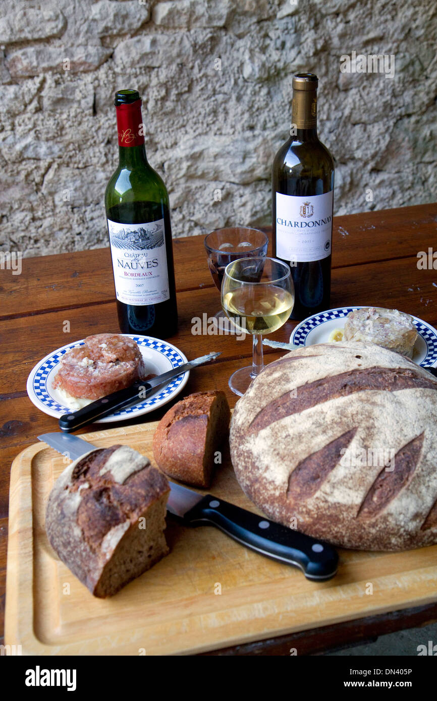 Wein, Brot und Pastete angezeigt auf einem französischen Bauernhof-Tisch in der Nähe von Angoulême im Südwesten Frankreichs. Stockfoto