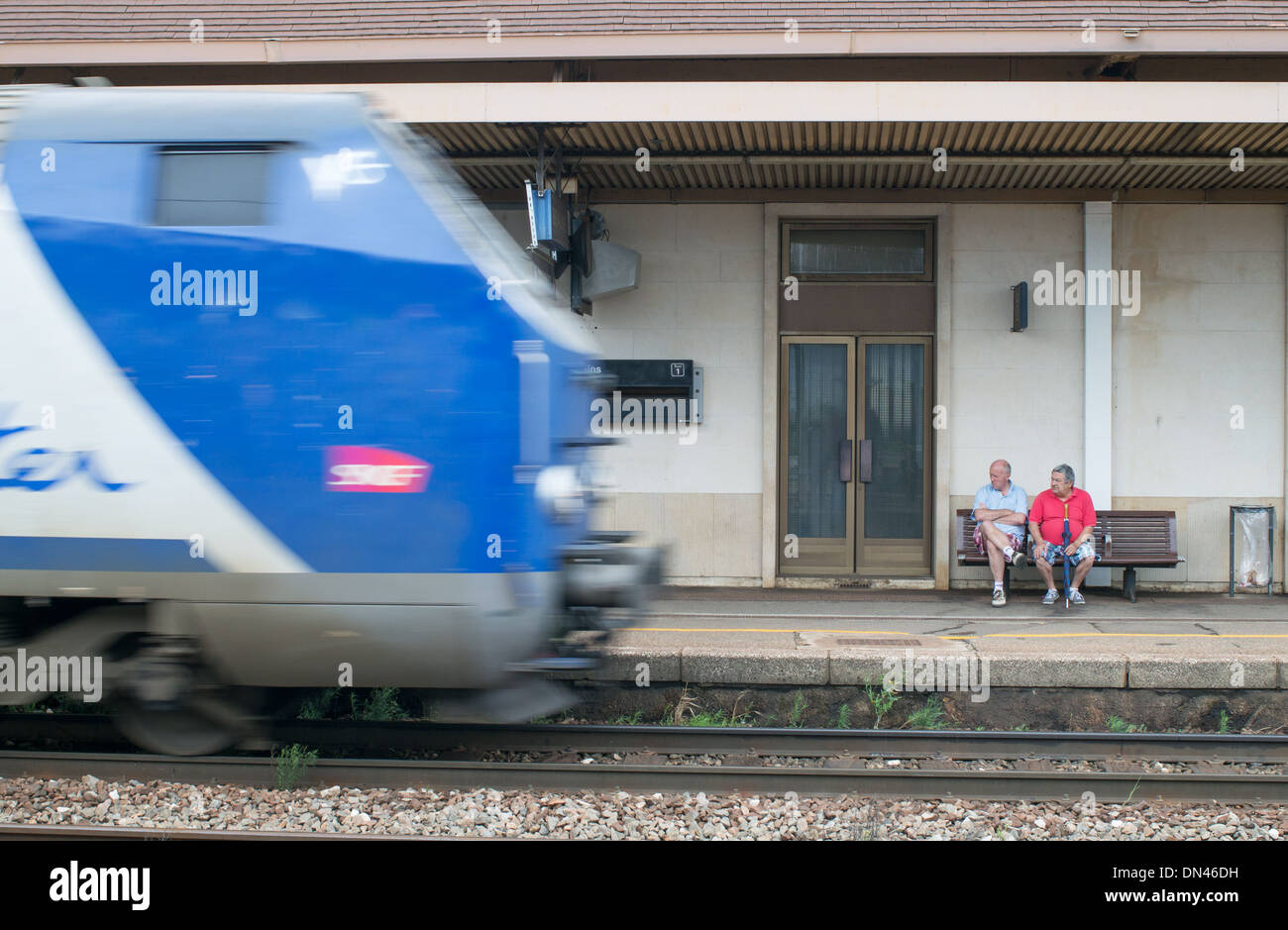 Geschwindigkeit verschwommen Zug fährt durch den Bahnhof von Beaune während zwei Passagiere auf, Burgund Frankreich Stockfoto
