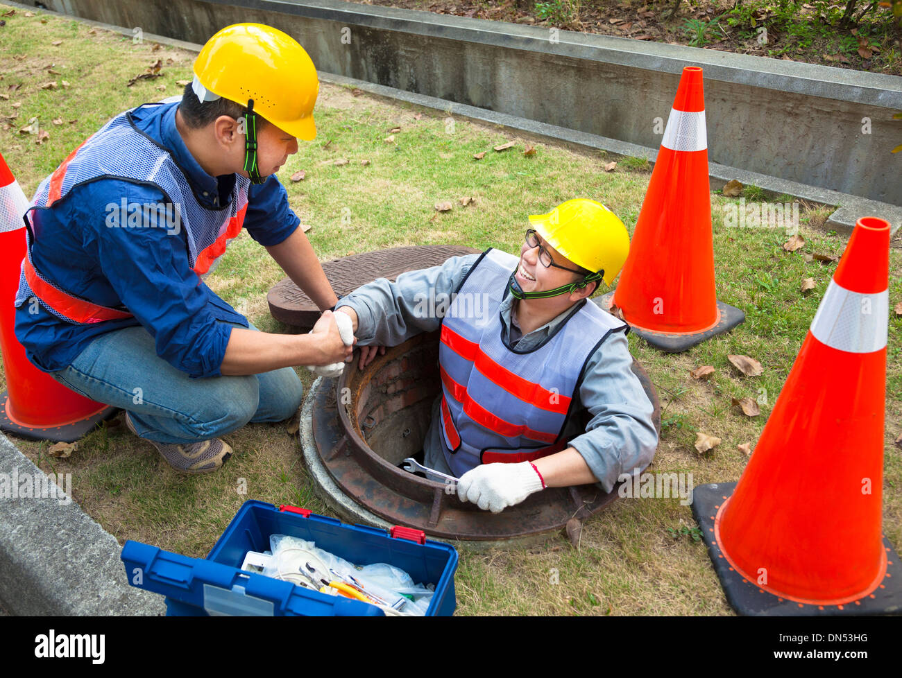 zwei Arbeiter der Kanalisation im Schacht Stockfoto