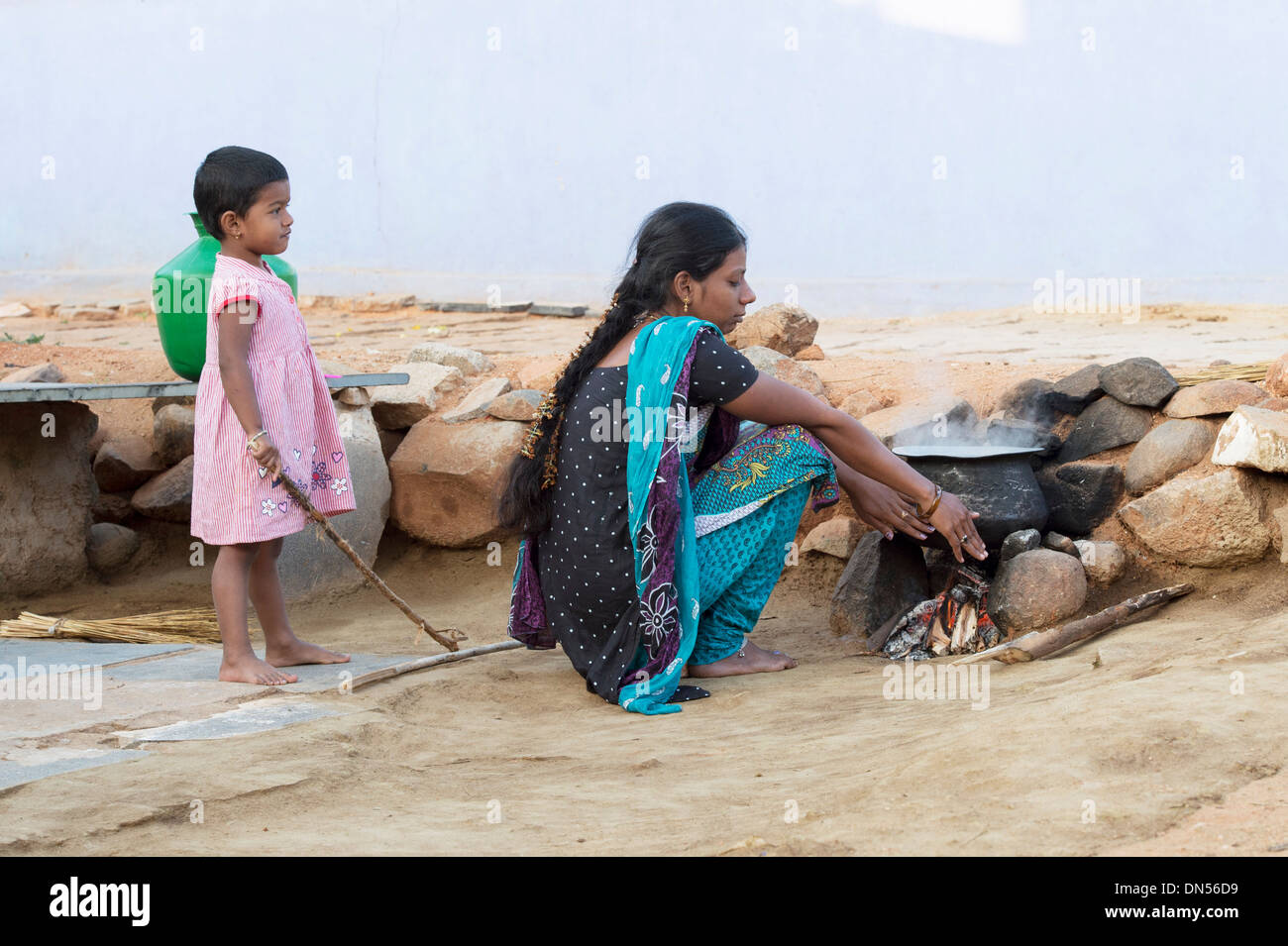 Indische Frau und Kind am offenen Kamin in einem indischen Dorf warm zu halten. Andhra Pradesh, Indien Stockfoto