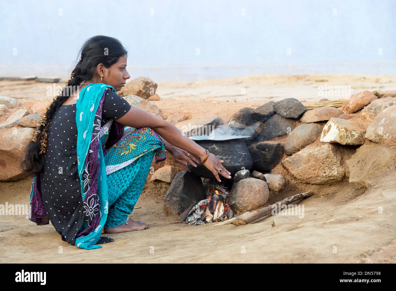 Indische Frau Warmhalten von offenem Feuer in einem indischen Dorf. Andhra Pradesh, Indien Stockfoto