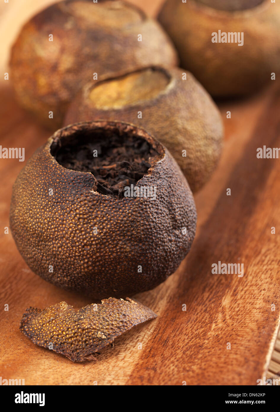 PU-Erh. Chinesischer Tee verpackt in getrockneten Mandarinen auf Holztisch Stockfoto