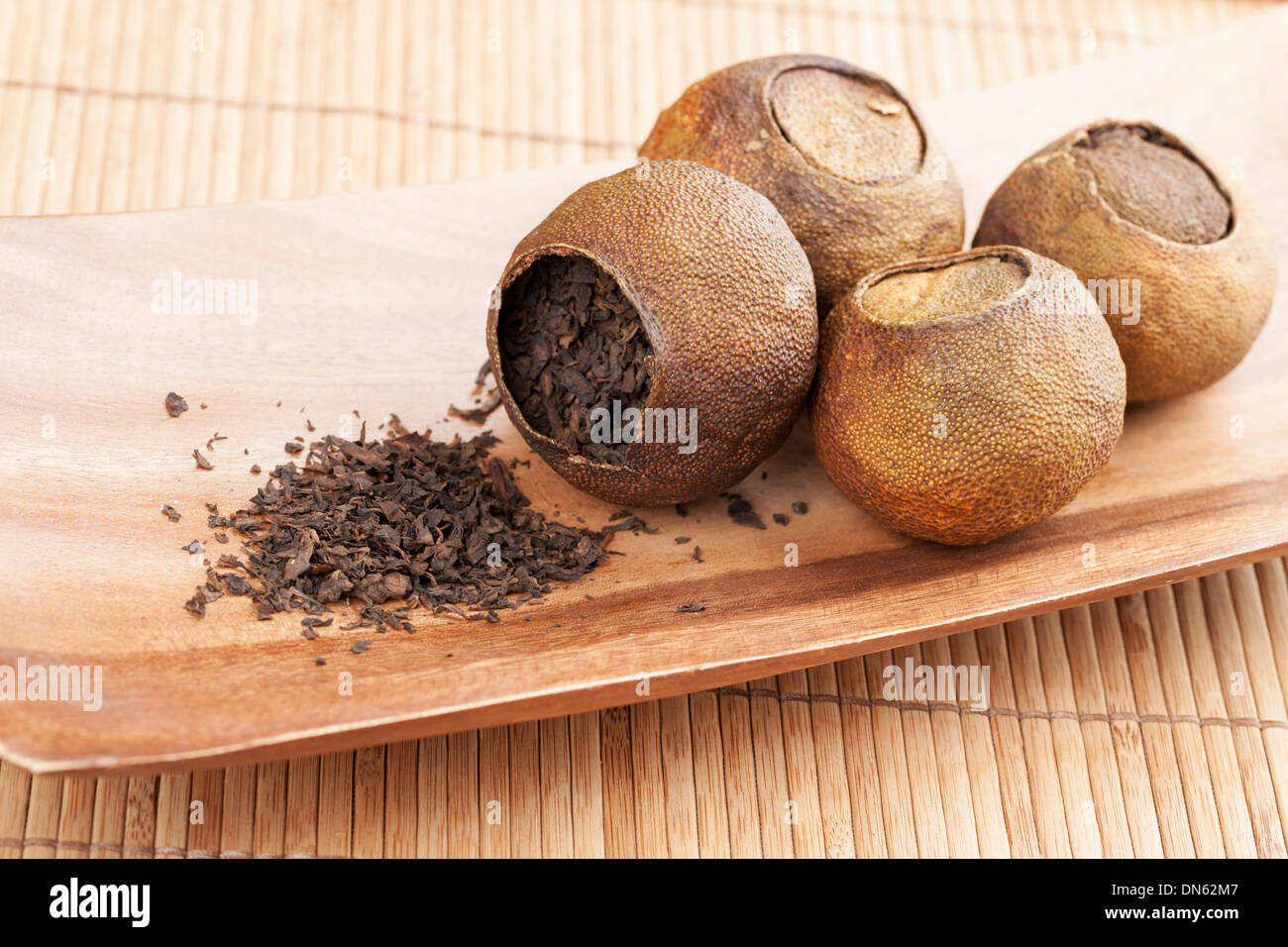PU-Erh. Chinesischer Tee verpackt in getrockneten Mandarinen auf Holztisch Stockfoto
