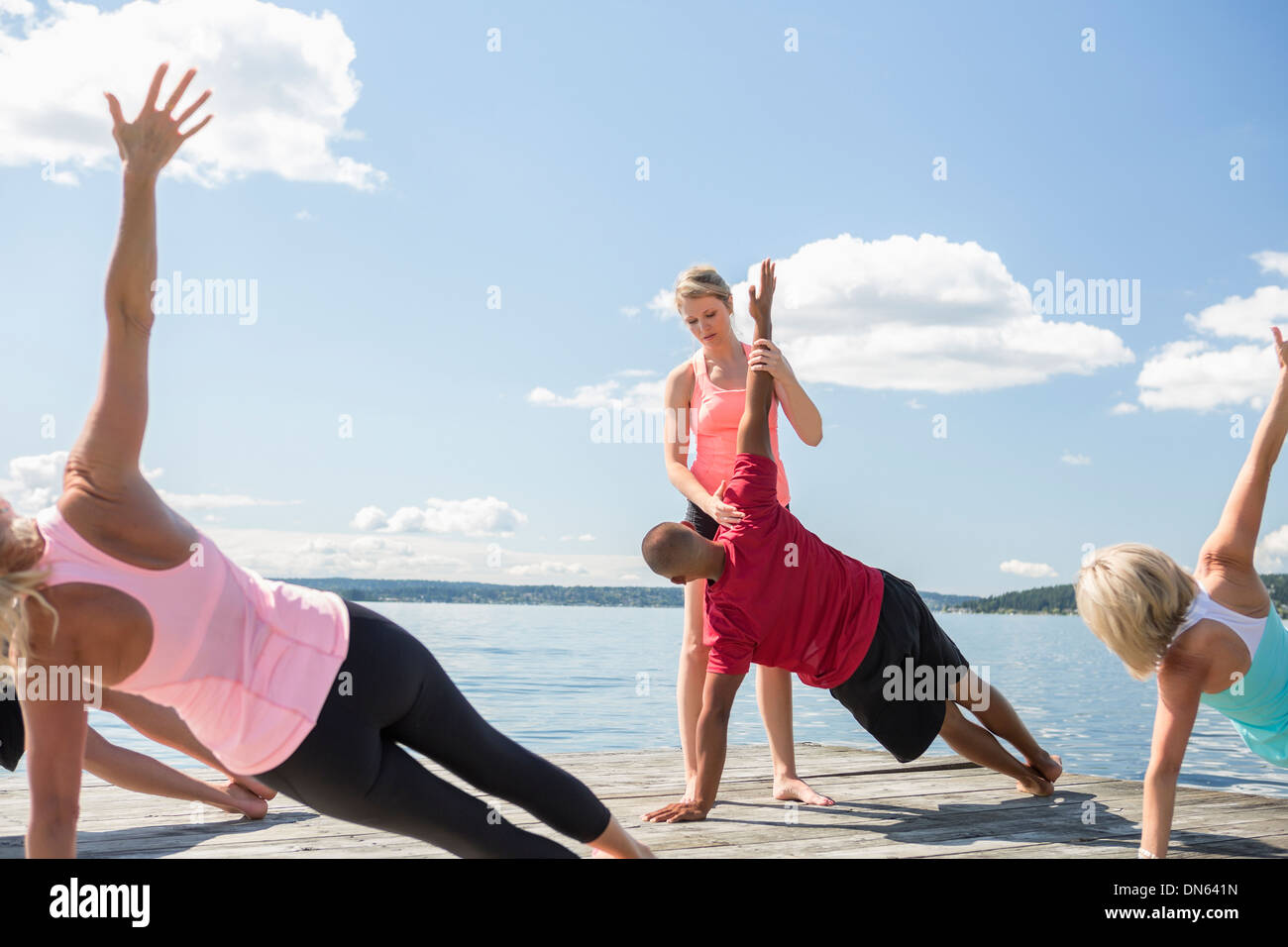 Dock-kaukasische Menschen praktizieren Yoga auf Holz Stockfoto