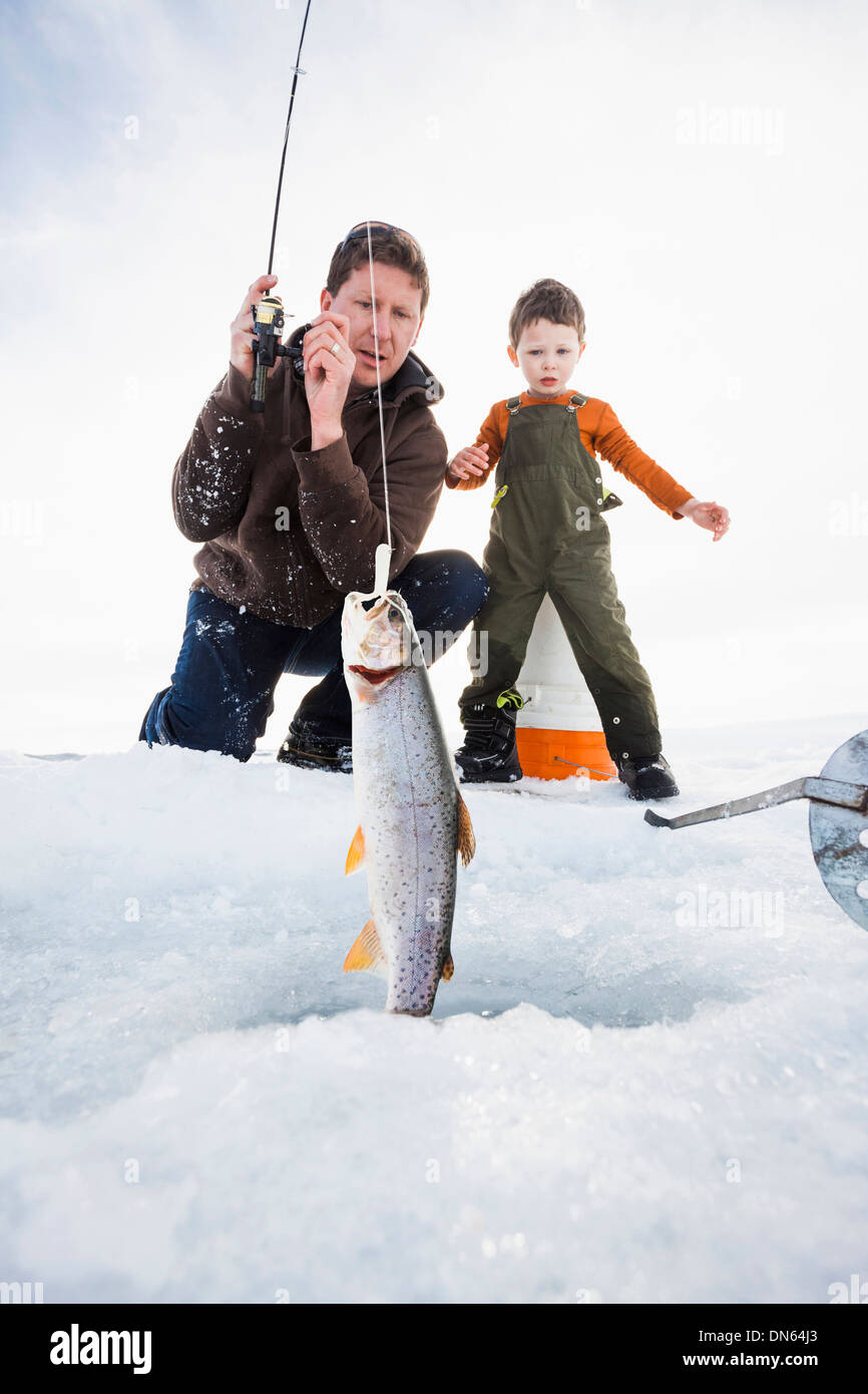 Kaukasische Vater und Sohn Eisfischen Stockfoto
