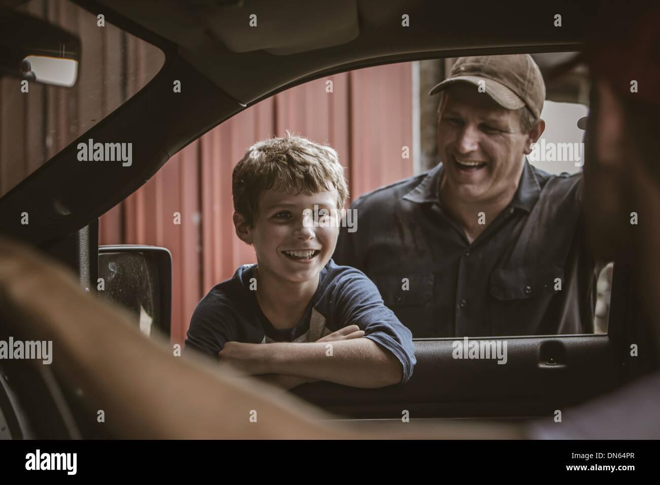 Kaukasische Vater und Sohn im Autofenster sprechen Stockfoto