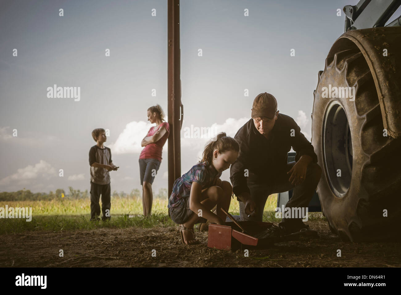 Kaukasische Vater und Tochter arbeiten an Traktor Stockfoto