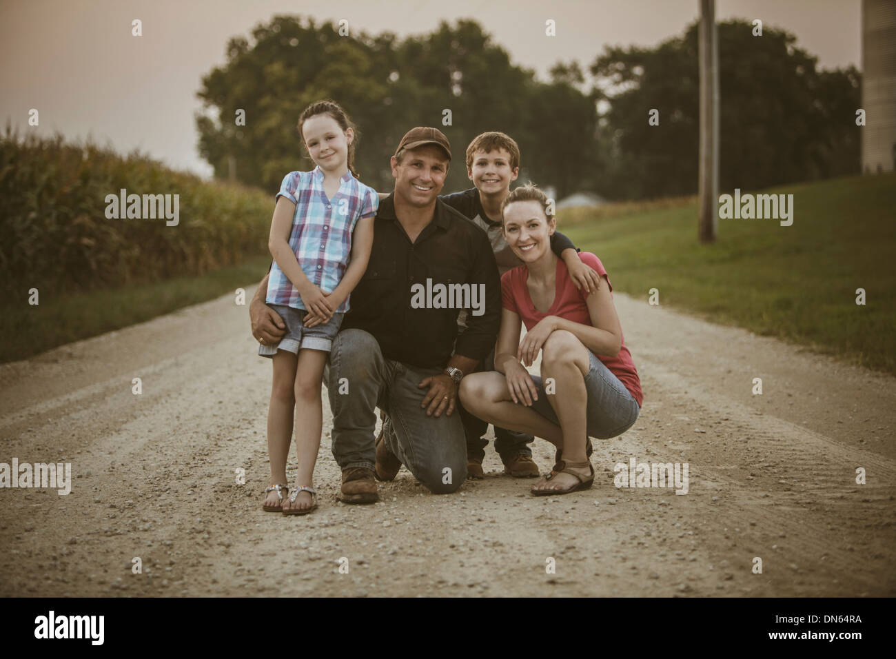 Kaukasische Bauer und Familie lächelnd auf Feldweg Stockfoto