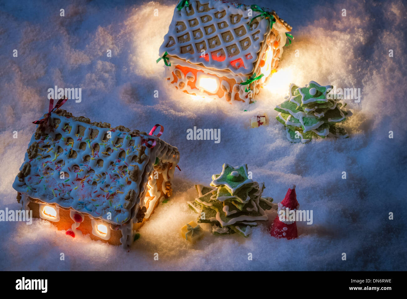 Verschneite Lebkuchen-Häuschen mit Weihnachtsmann und Geschenke Stockfoto