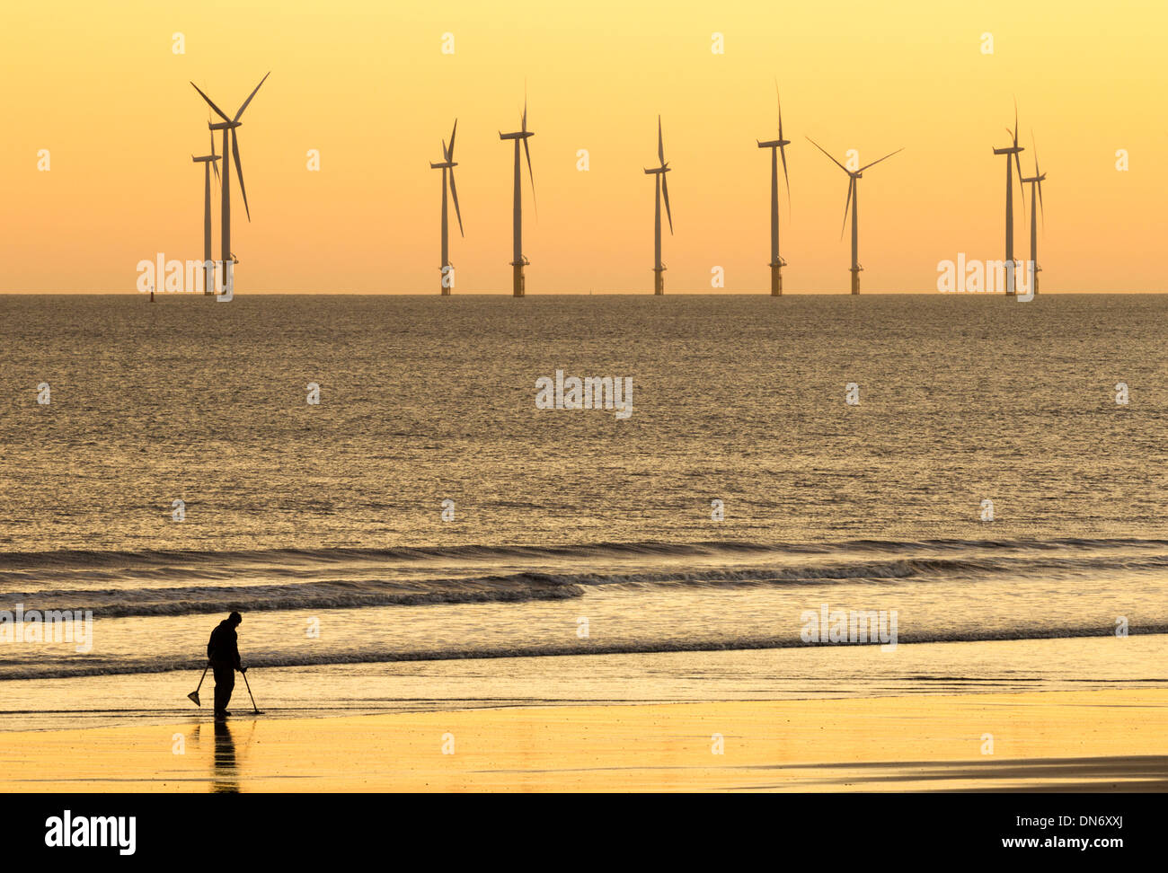 Mann Metalldetektor mit Metalldetektor am Strand. Großbritannien Stockfoto
