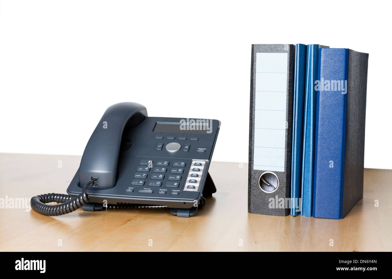 moderne Business-Telefon mit Ringbuch einen Ordner auf dem Schreibtisch aus Holz Stockfoto