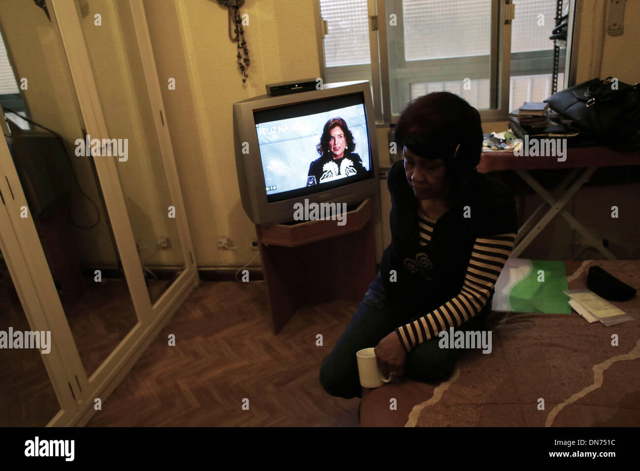Madrid, Spanien. 19. Dezember 2013. Ana Botella, Madrids Bürgermeister erscheint im Fernsehen mit einer Meldung darauf es ist geschrieben '' Frohe Weihnachten '' als Antonia Mendez Sangroni 63 Jahre alt, venezolanische, wartet in Madrid, Spanien, Donnerstag, 19 Dez. 2013.Antonia Mendez Sangroni 63 Jahren geräumt werden Venezuela, kaufen eine Wohnung vor 5 Jahren, lebt mit seinem Sohn, Sandy Villal Mendez-40-jährige, wer der Eigentümer des Hauses ist , Aufgrund der Finanzkrise Sandy ging in USA, Arbeit zu suchen, verlassen ihre Mutter in Spanien mit der Belastung der Hypothek, einen Vertrag mit Bankia. Ihr nur monatliches Einkommen besteht Stockfoto