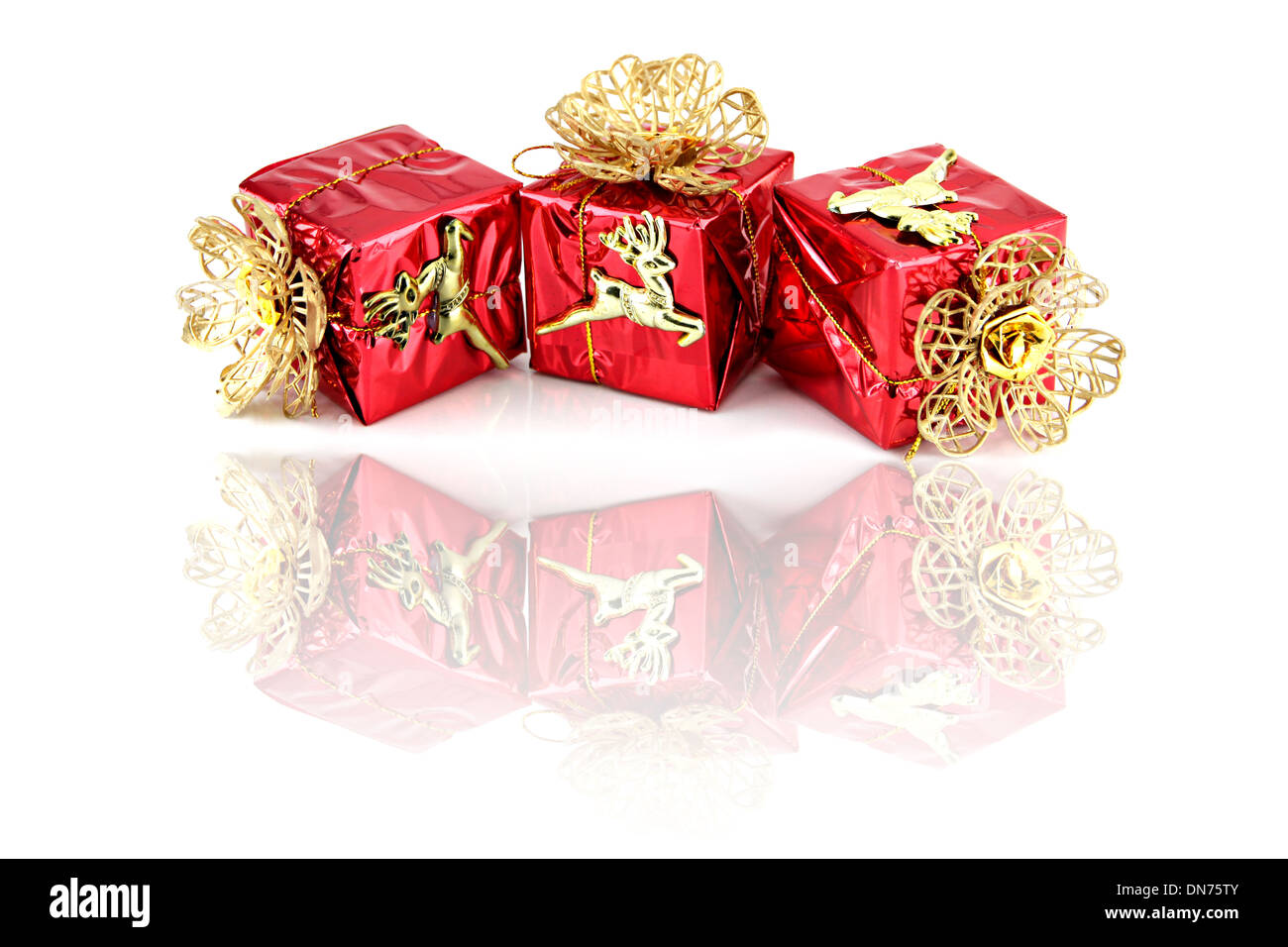 Roten Geschenkbox und Gold Rentiere haben Reflexionen auf weißem Hintergrund. Stockfoto