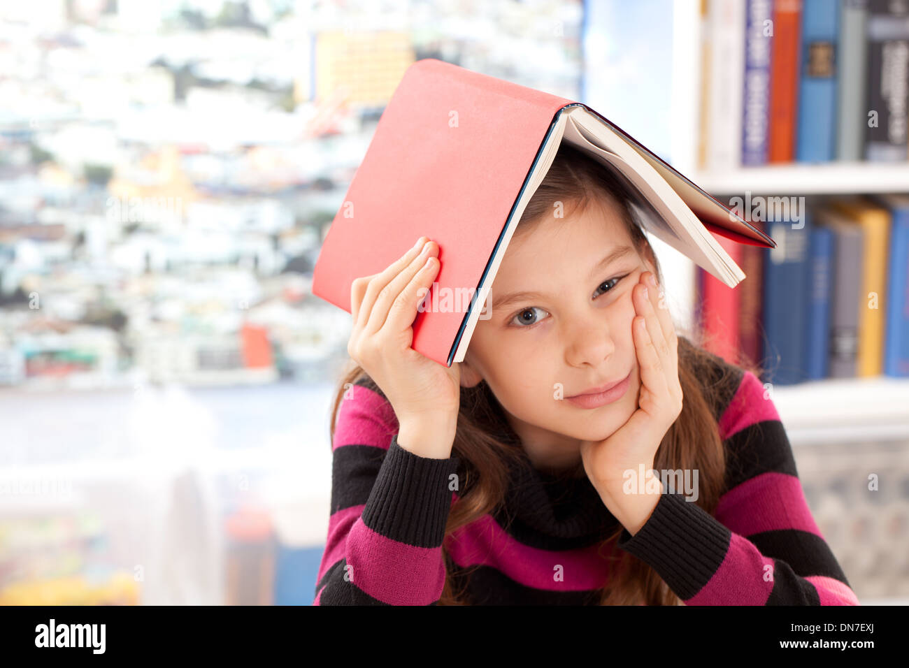 Mädchen mit einem Buch auf dem Kopf als Symbol für ein burnout Stockfoto