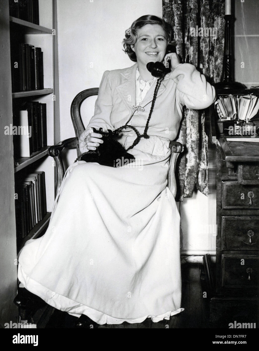 24. November 1953 - verwendet London, England, Vereinigtes Königreich - Frau von Captain A.C. Loraine, MARY LORAINE immer noch in ihr Nachthemd und Morgenmantel das Telefon zu einem Freund erzählen, dass die Polizei ihr Schlafzimmer auf Spurensuche nach einem großen Raub verschlossen haben. Stockfoto